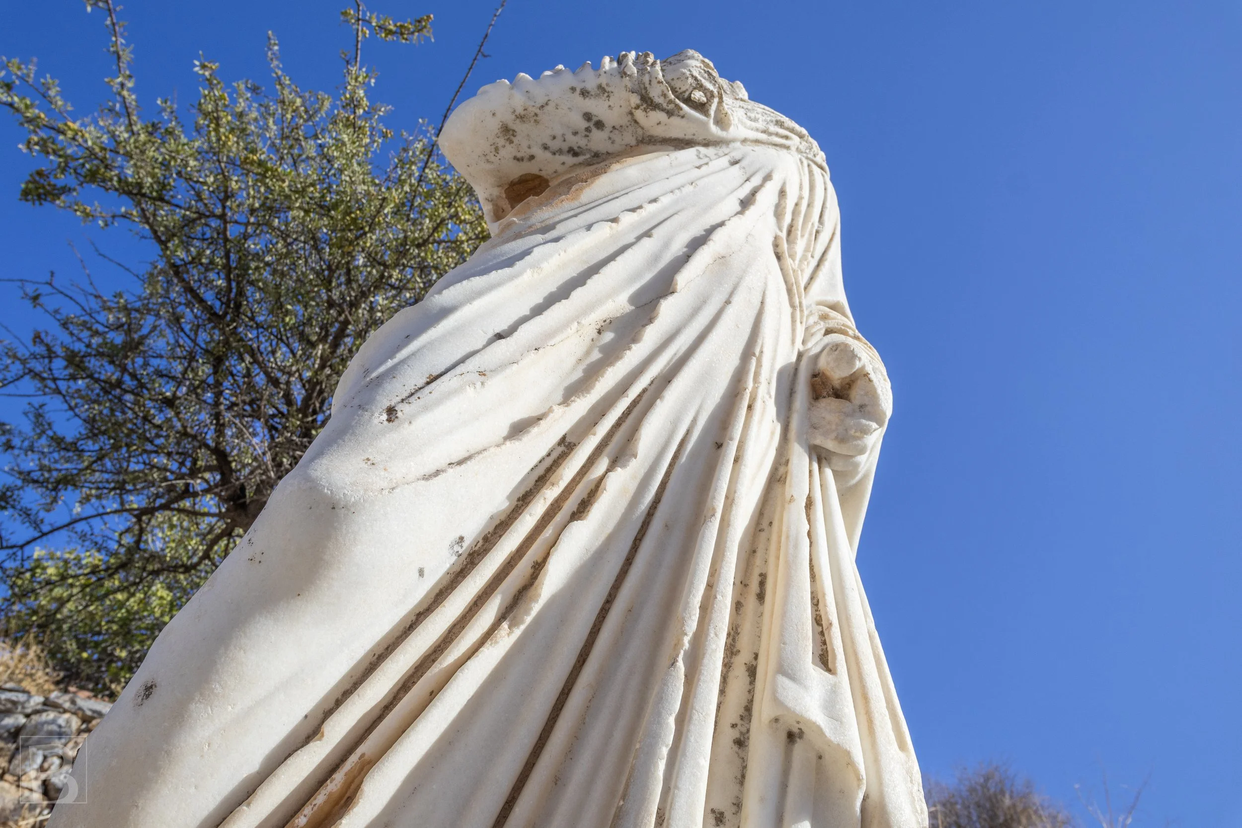 Folds cut into stone give movement and weight to a figure weathered
by centuries.