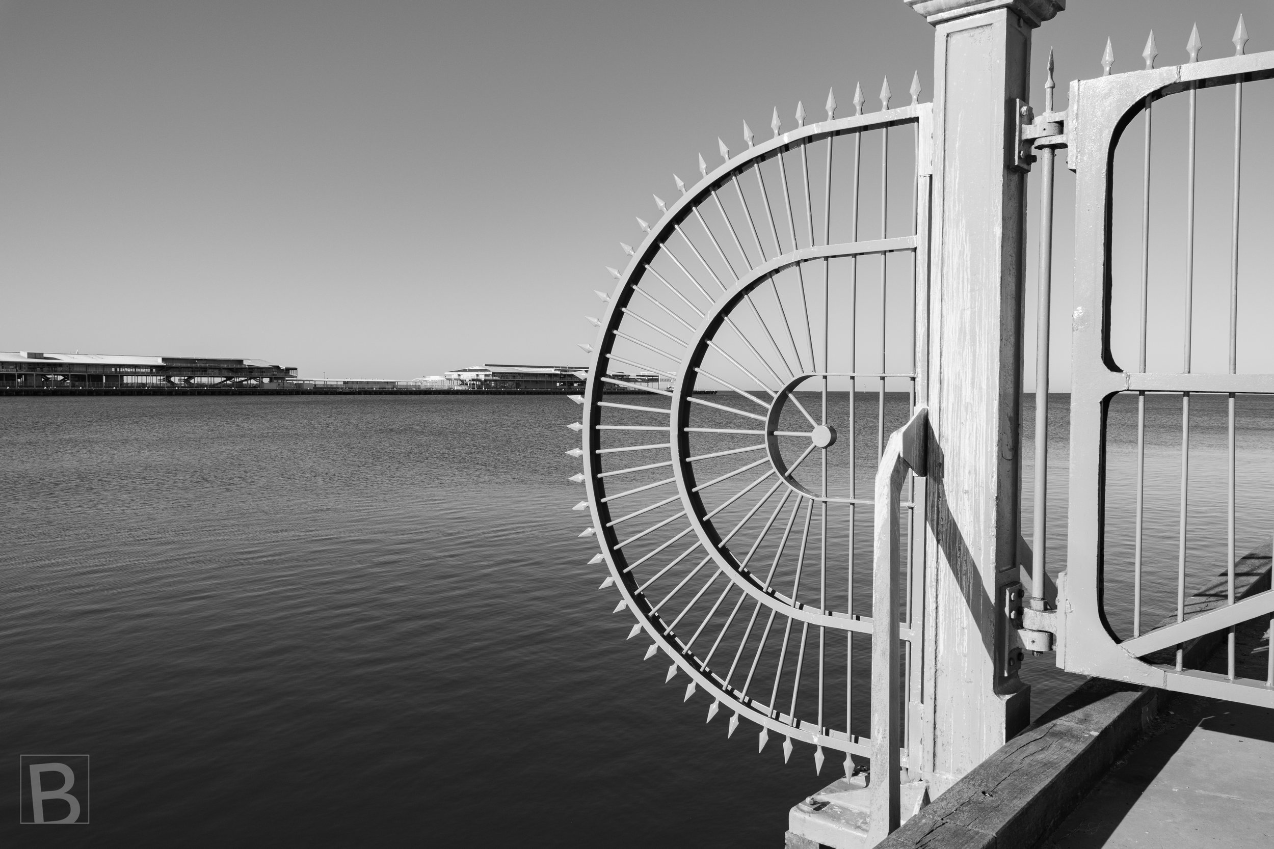 The radial geometry of a waterfront gate turns a functional barrier into
a striking study of line, repetition and negative space.