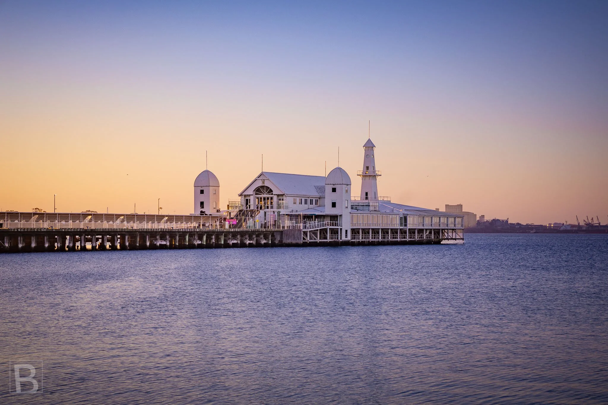 The distinctive pavilion of Cunningham Pier extends across calm
water at dusk, joining Geelong's maritime history with the evening
horizon.