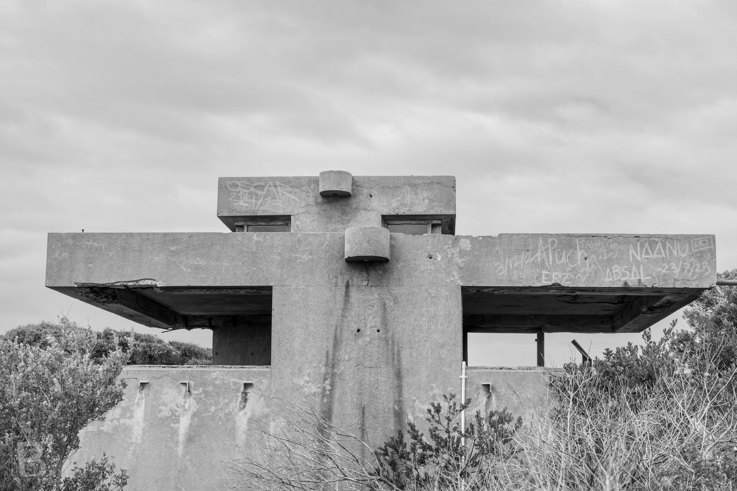 The blunt form and narrow openings of an abandoned coastal bunker
record an earlier landscape of surveillance and defence.
