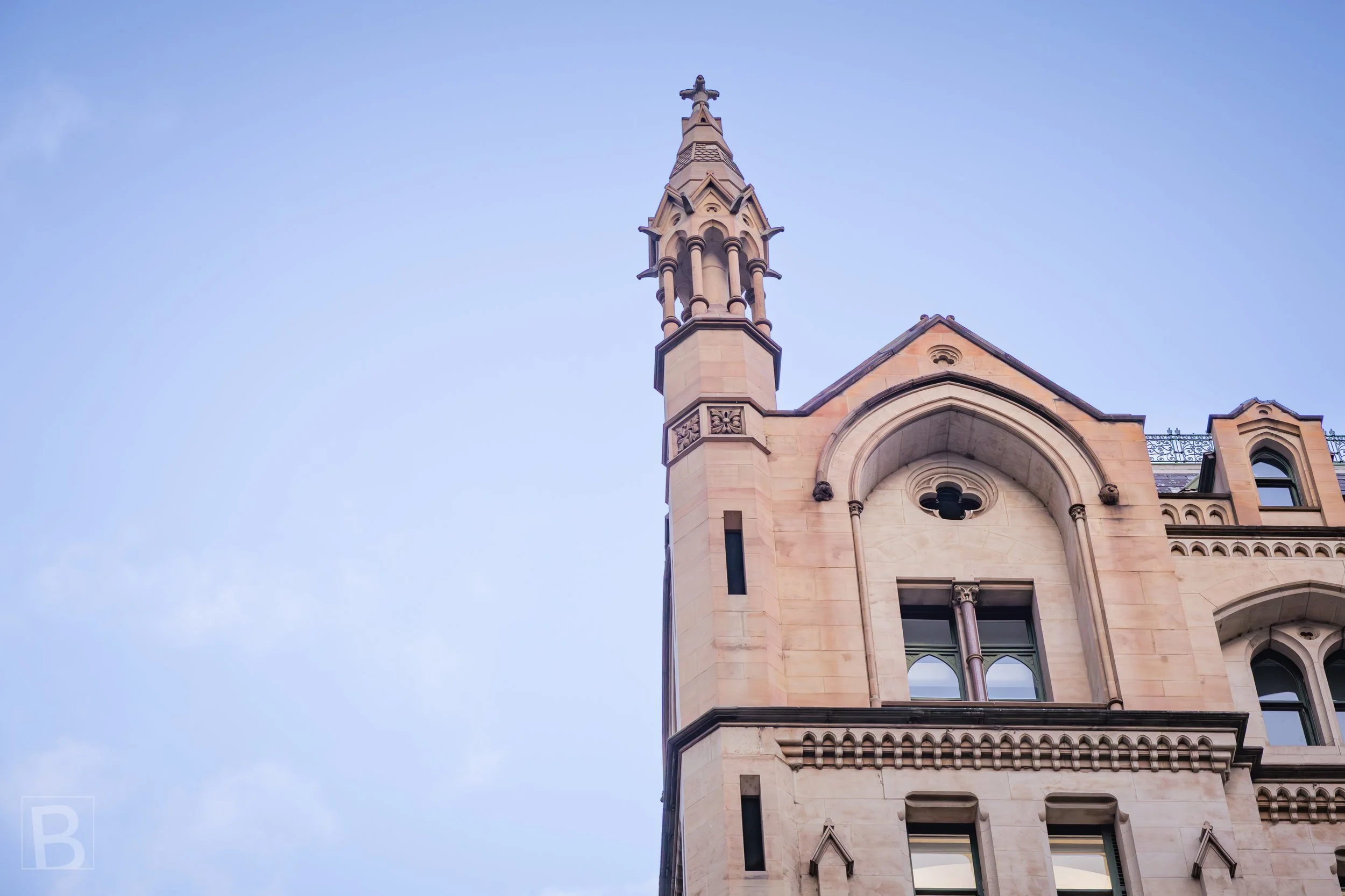 Arches, carved stone bands and a delicate turret give this historic city
building a distinctive vertical silhouette.