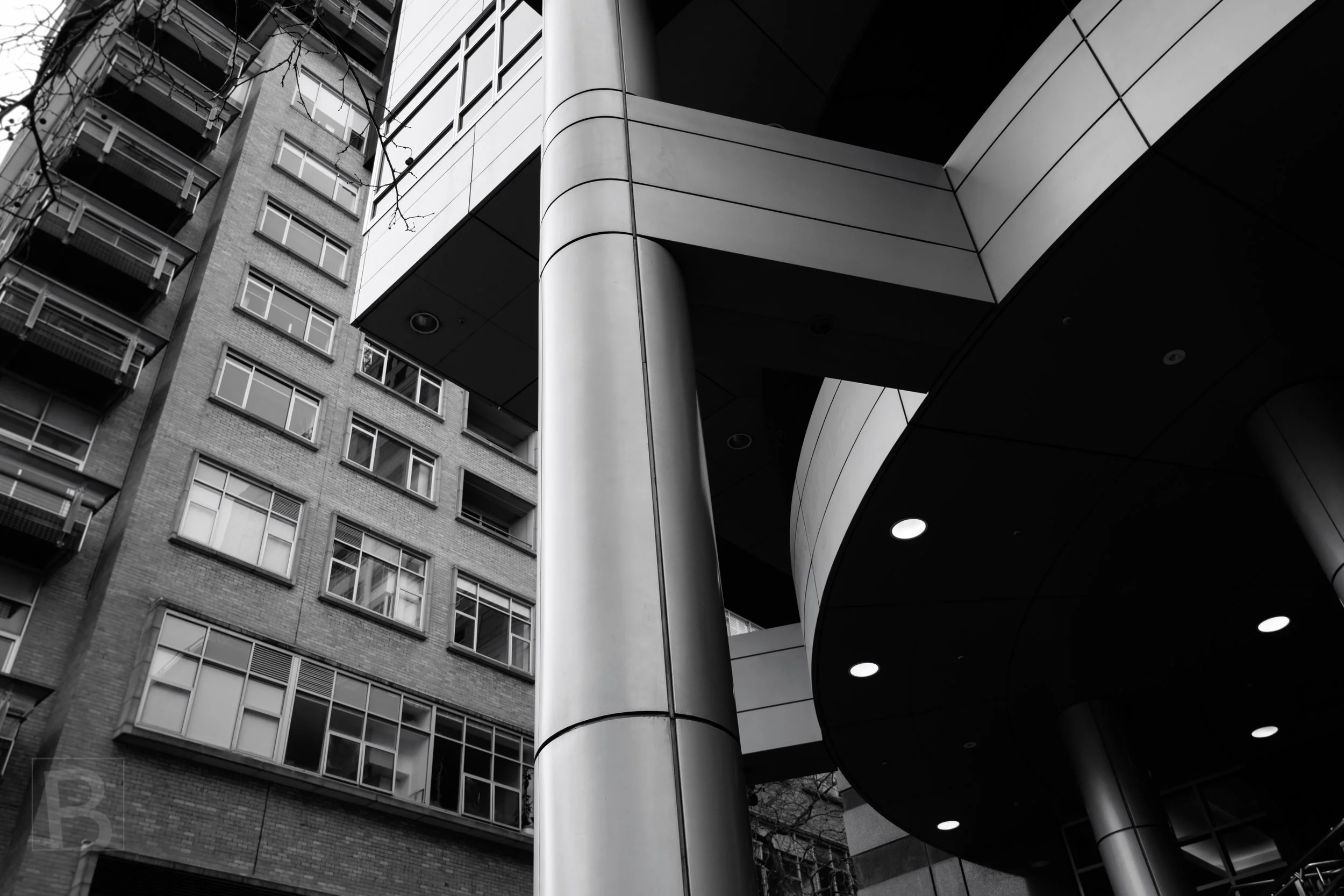 Modern cladding and older masonry converge above the street,
revealing the layered geometry of a changing city.