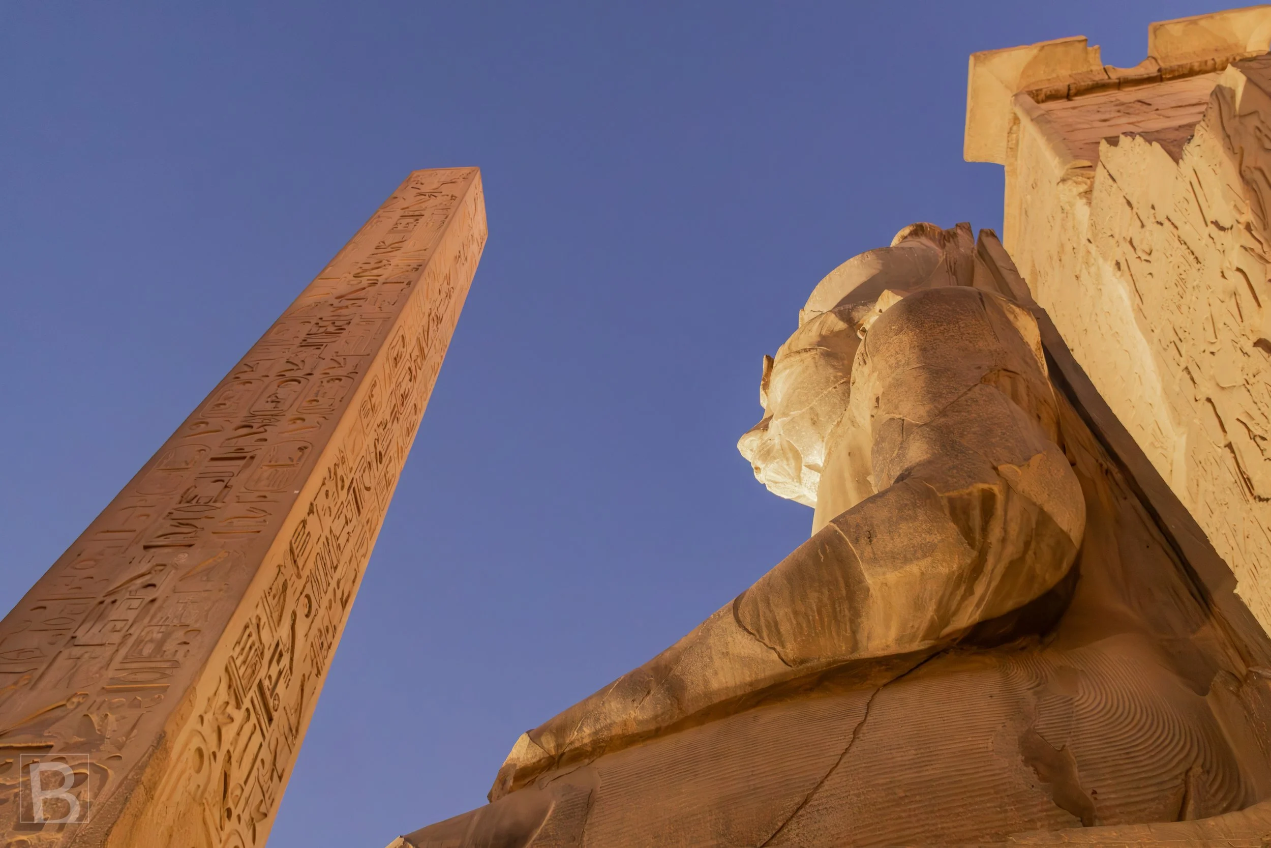 Warm night lighting reveals the monumental pairing of royal sculpture
and inscribed stone at Luxor Temple.