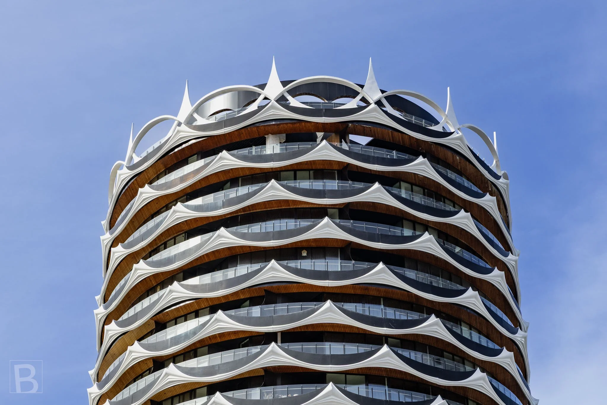 Curved terraces and crisp white ornament give the residential tower a
distinctive crown and highly patterned facade.