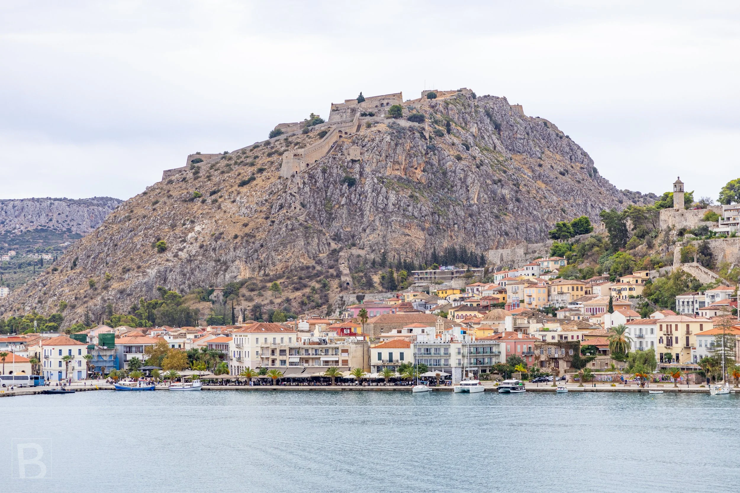 The harbour town of Nafplio stretches beneath Palamidi Fortress,
layering coastal settlement, stone engineering and mountain terrain.