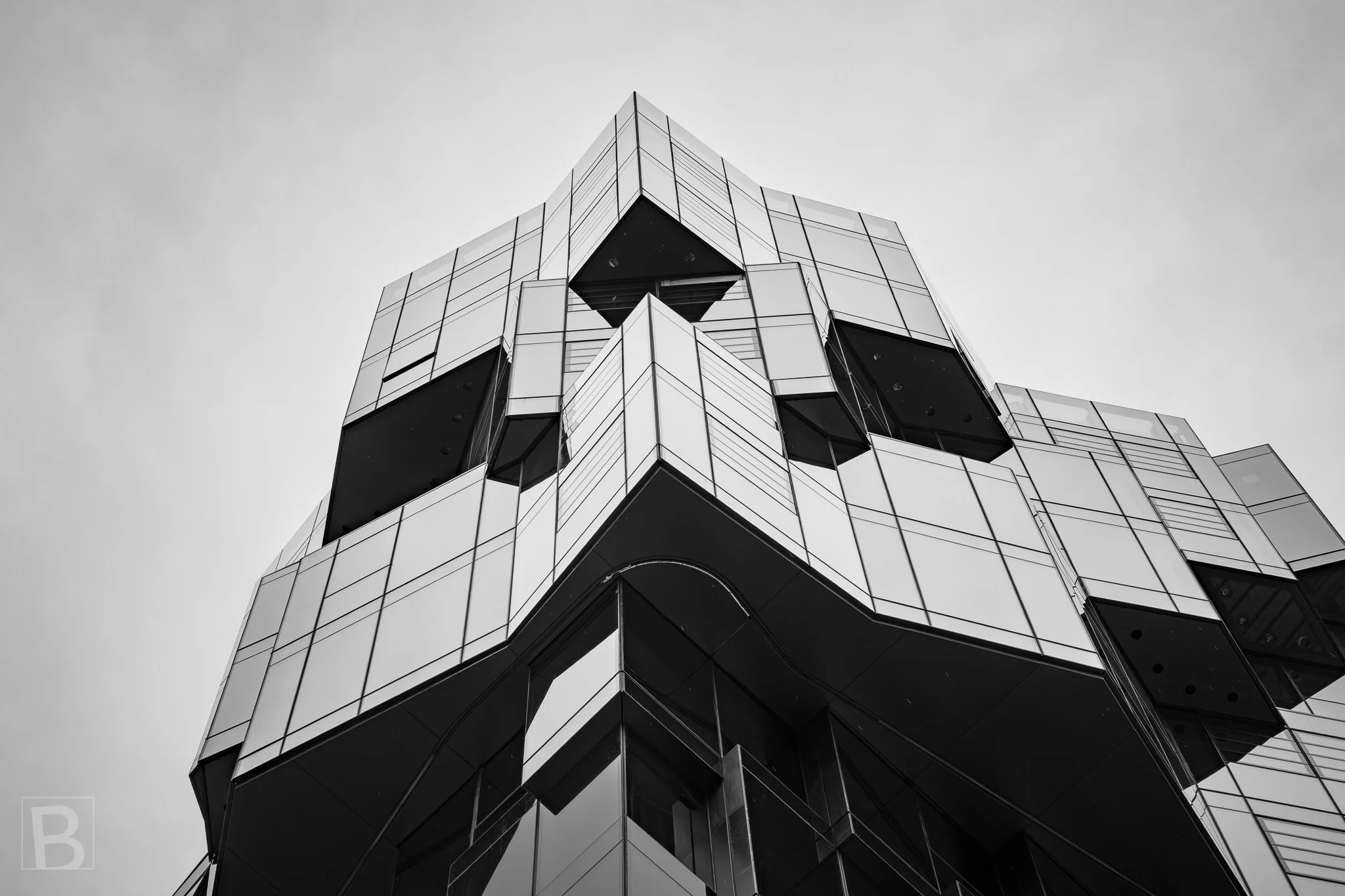 Sharp planes and deep window boxes turn a city facade into an
abstract composition of light, shadow and folded geometry.