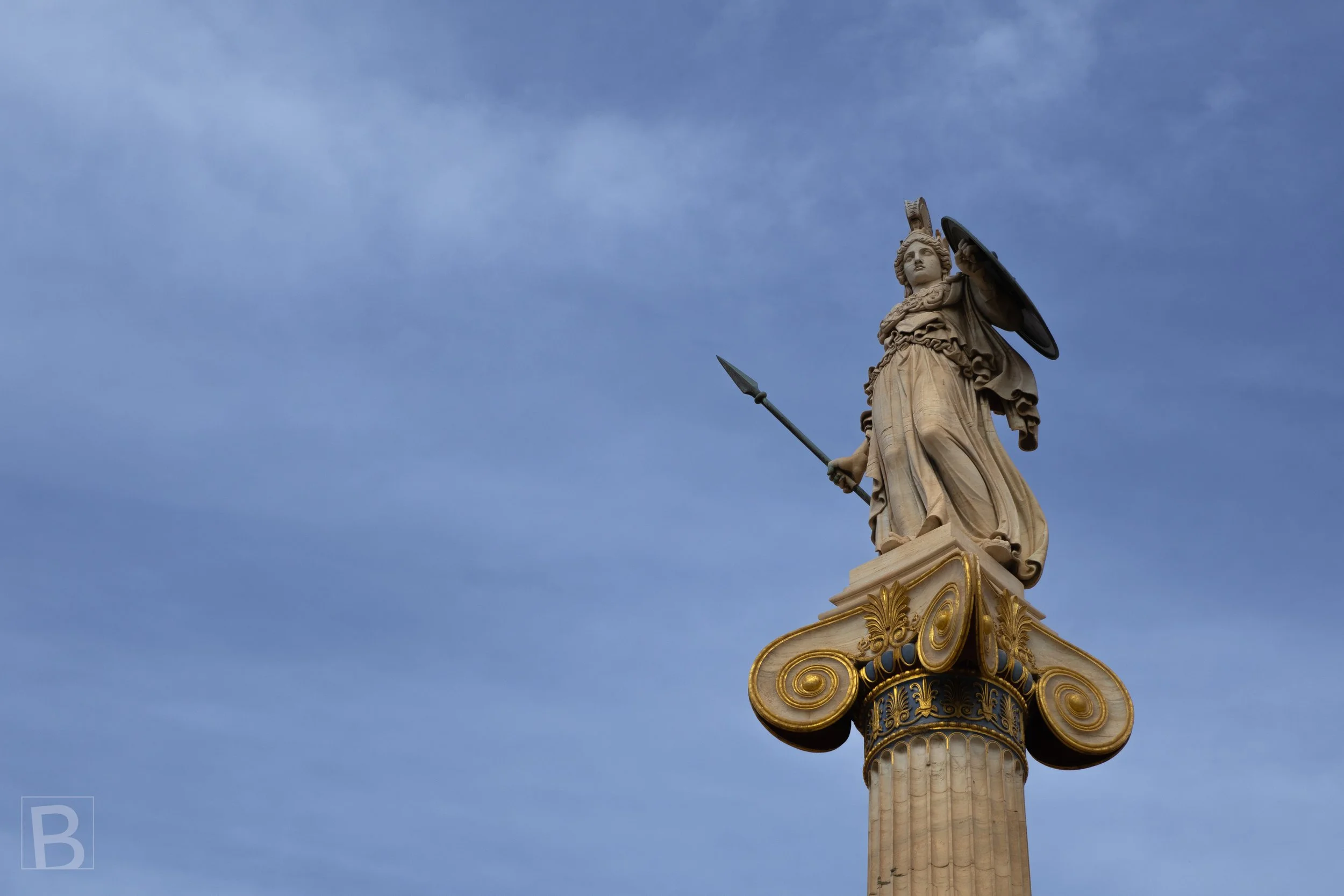 Athena's poised figure crowns a tall column, symbolising wisdom and
the ancient identity of the city.