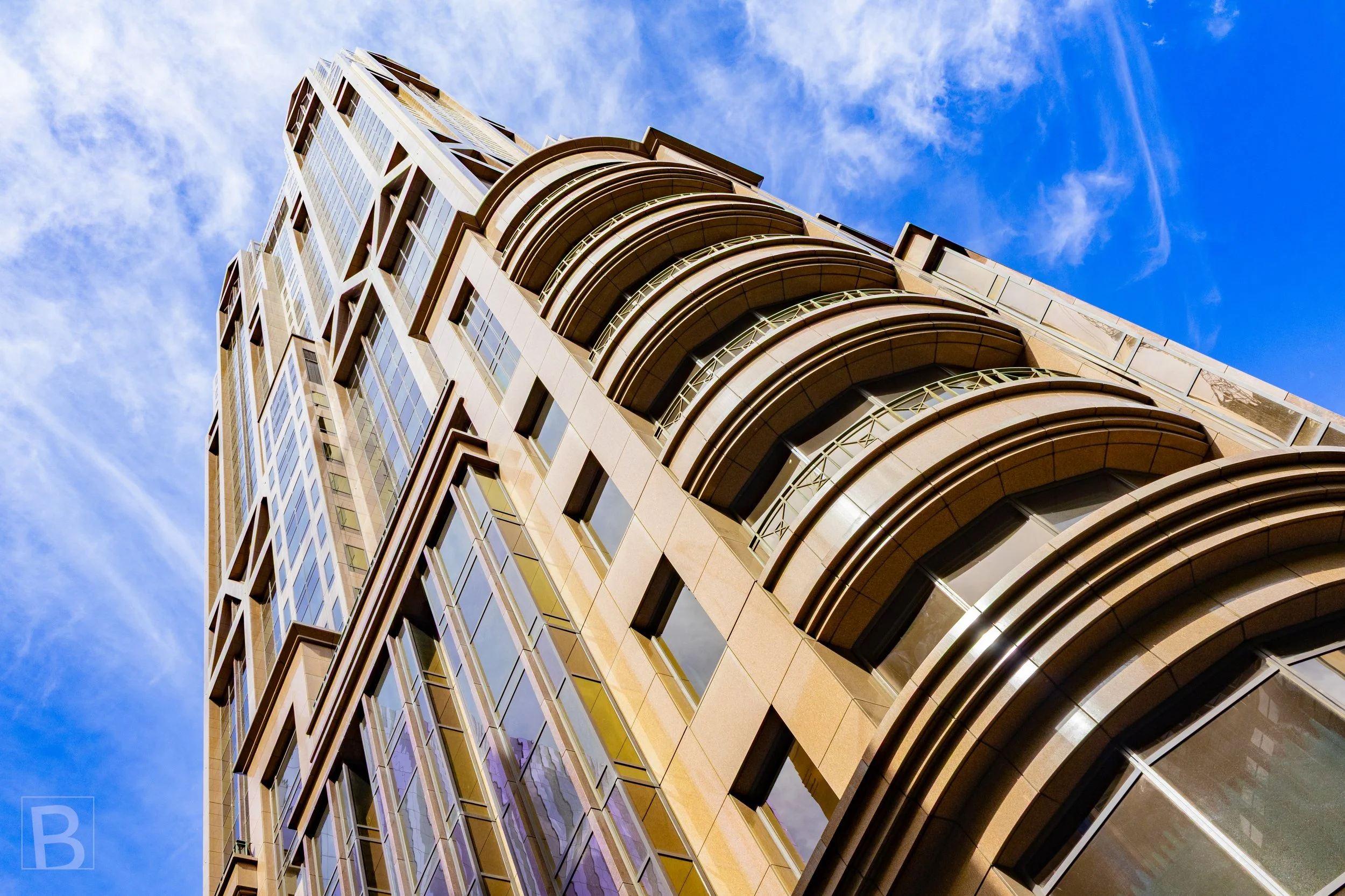 Layered curves and vertical glazing draw the eye upward, revealing
the streamlined elegance of a sculpted city facade.