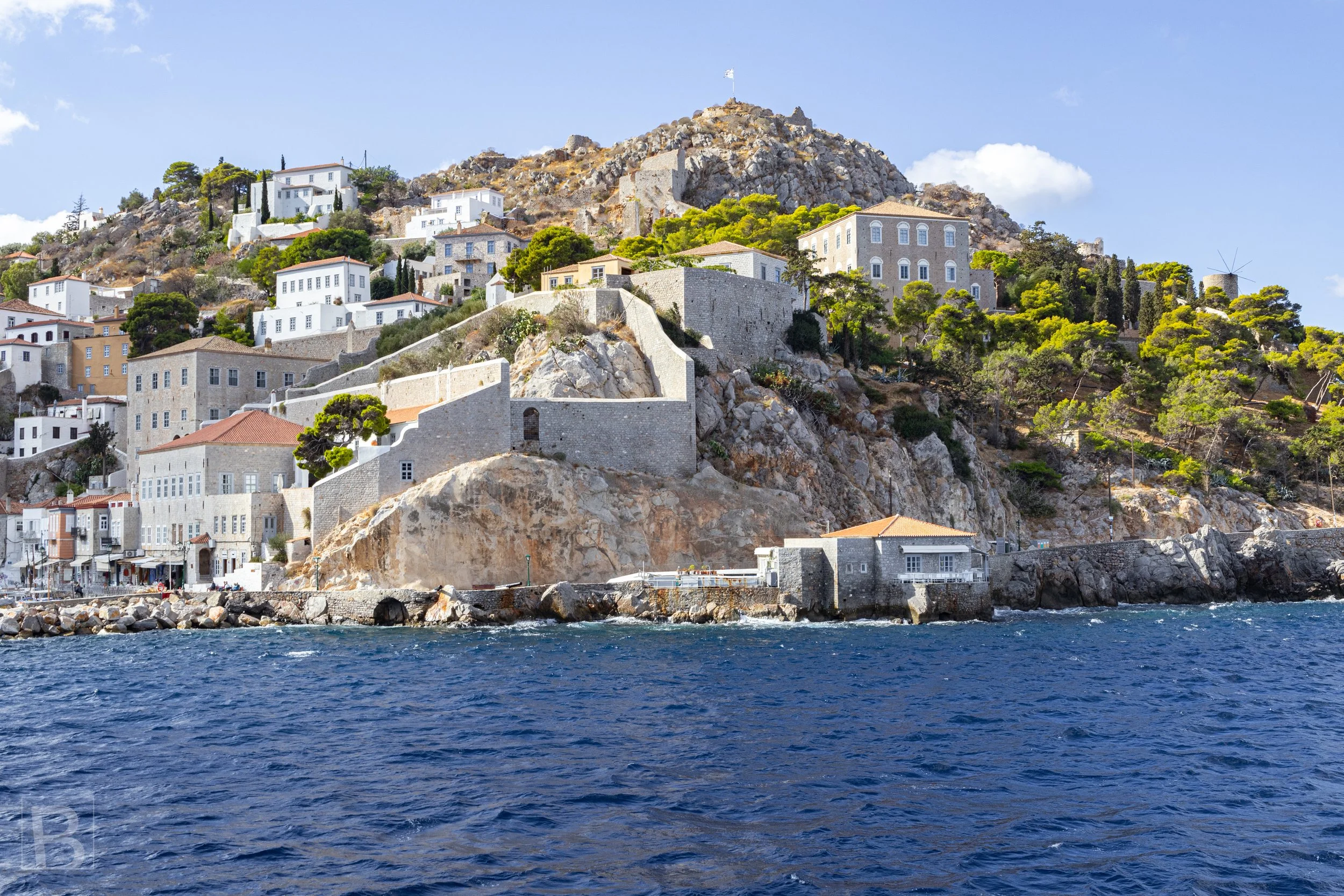 Hydra's pale stone buildings follow the steep shoreline, showing how
architecture, defence and daily life have adapted to the island
landscape.