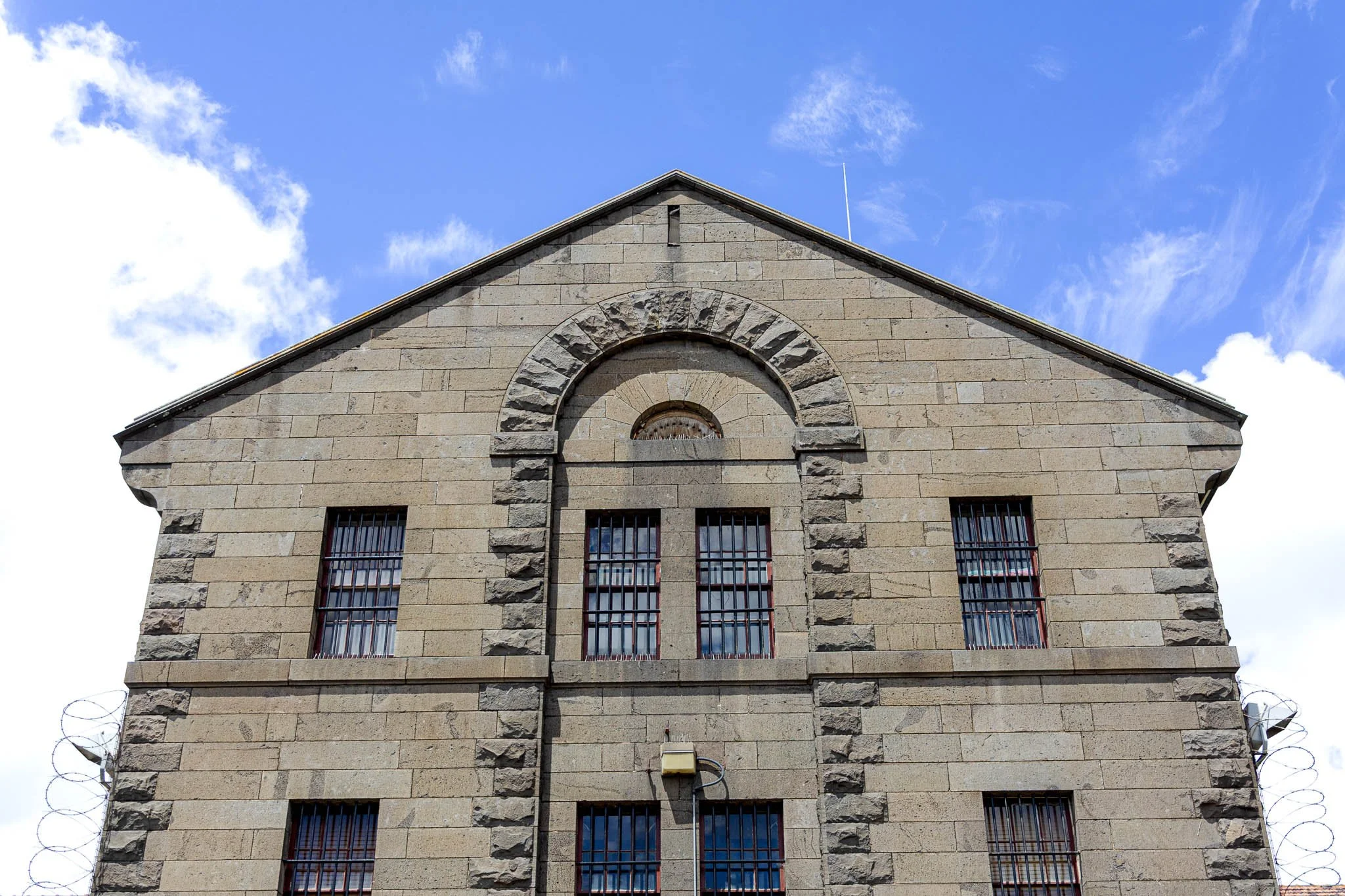 Rough masonry, iron bars and coiled wire preserve the severe
functional character of nineteenth-century prison architecture.