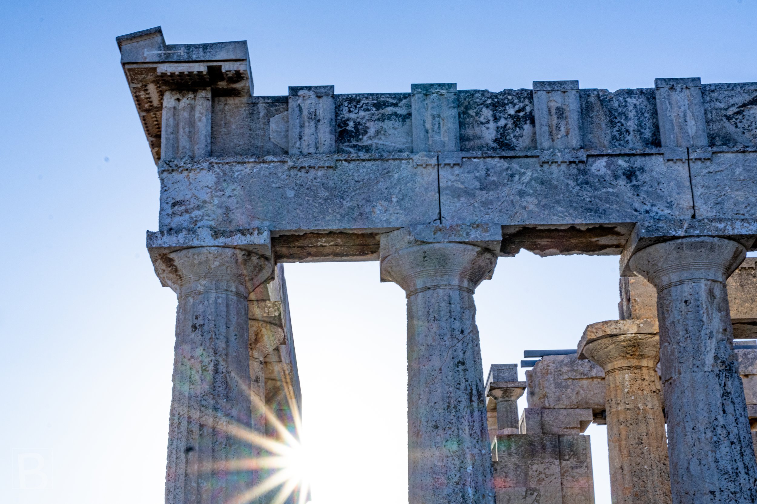 A sharp sunburst animates the weathered temple entrance, linking
ancient stone with the present moment.