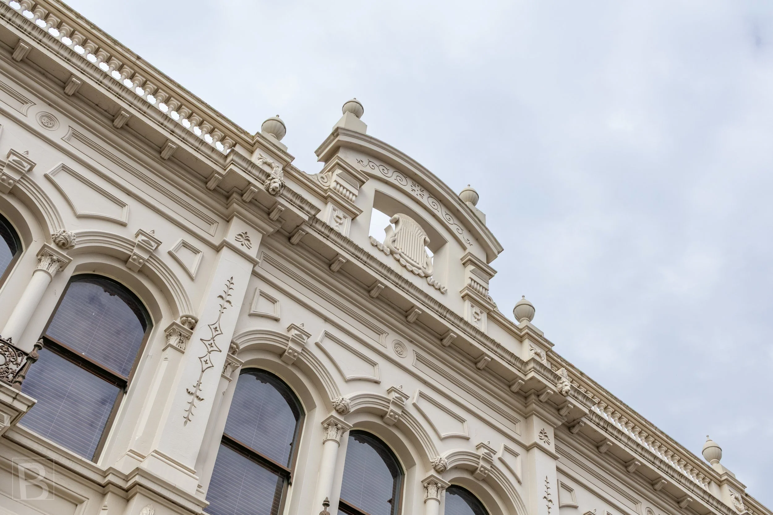 Layered ornament, curved windows and fine masonry details show
the craftsmanship invested in a nineteenth-century commercial
building.