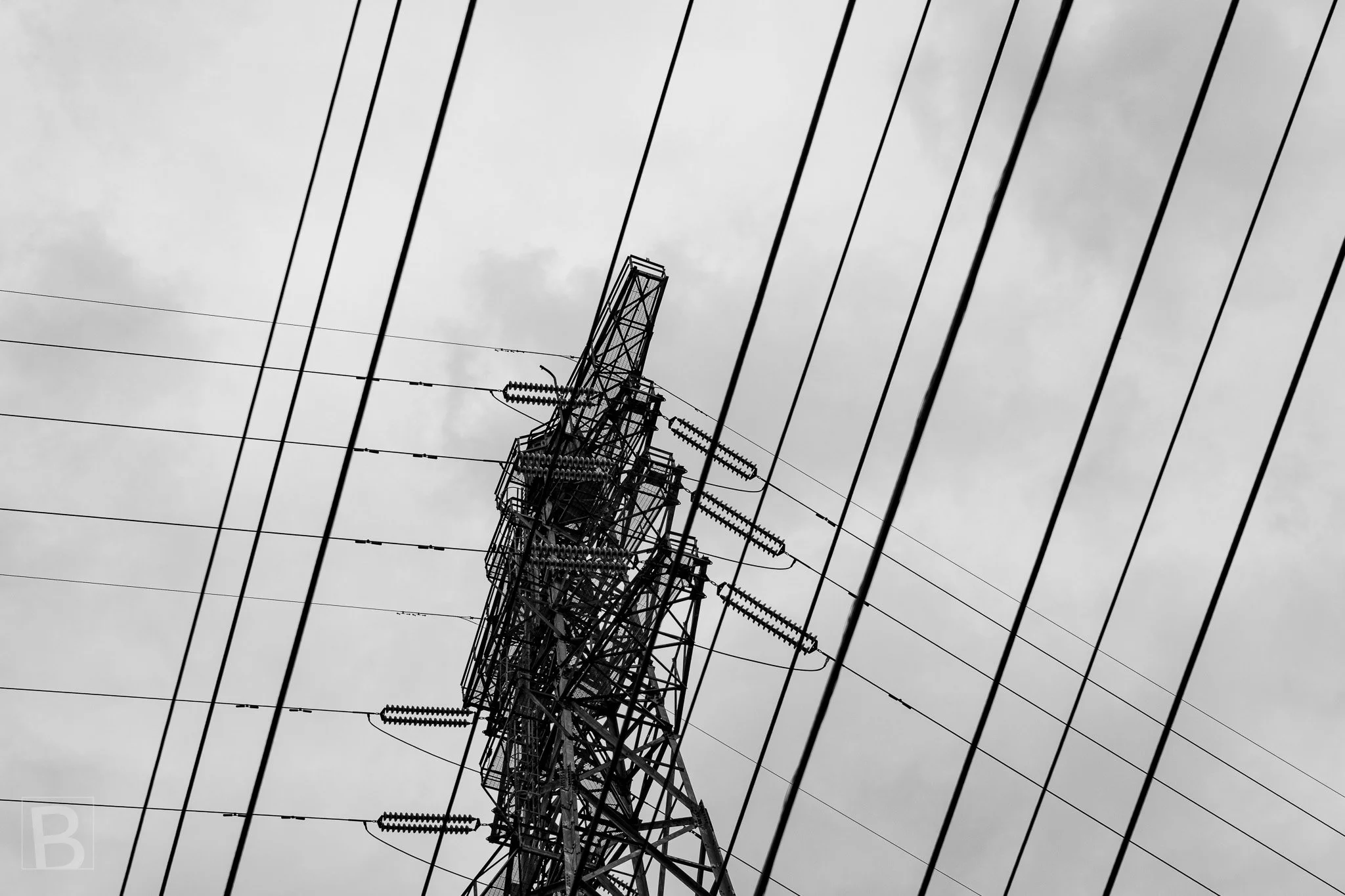 Cables sweep across a lattice transmission tower, revealing the
dense graphic order hidden within everyday infrastructure.
