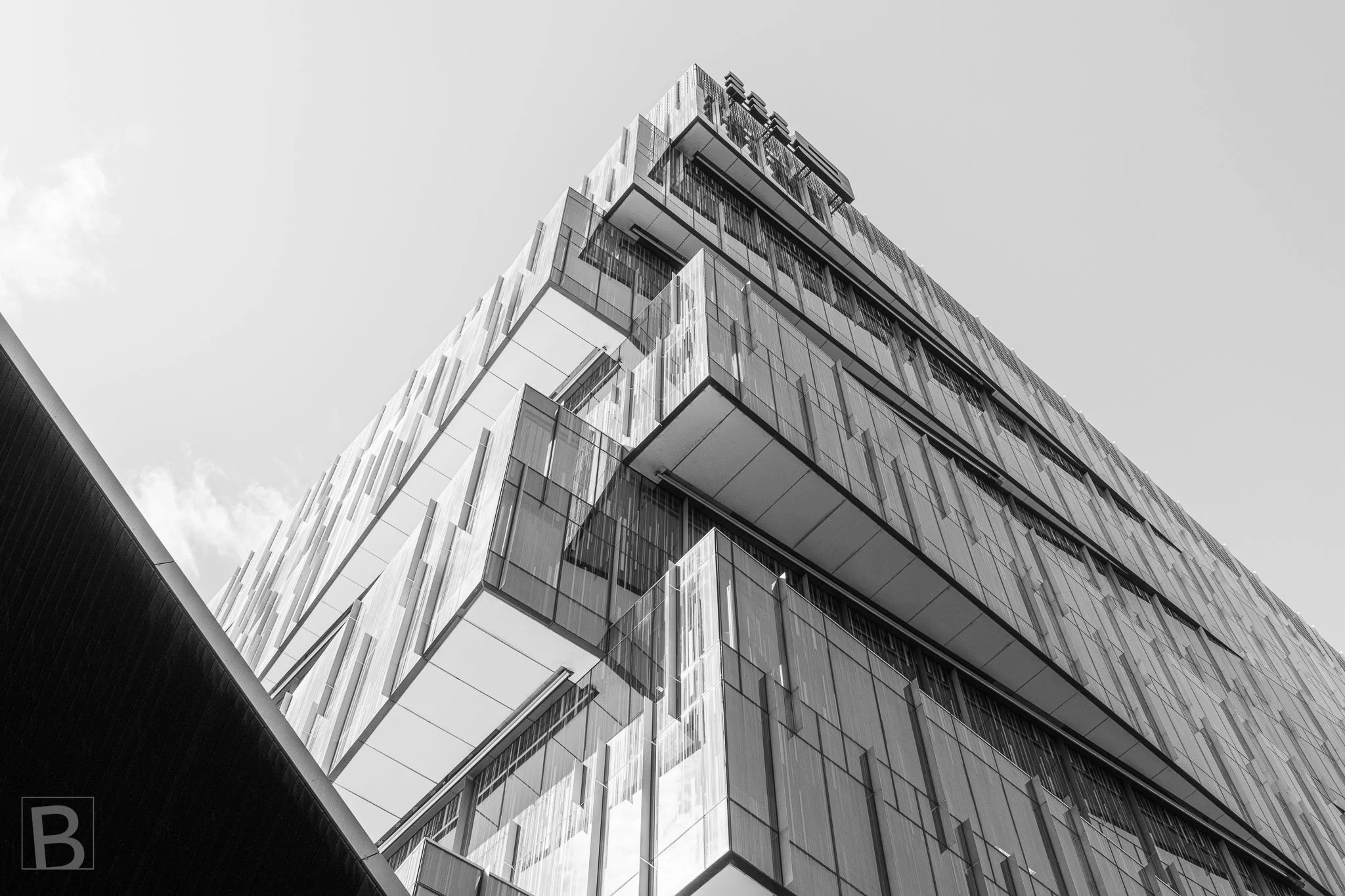 Overlapping glazed volumes shift outward as they rise, giving a large
urban building a dynamic sense of balance and suspension.