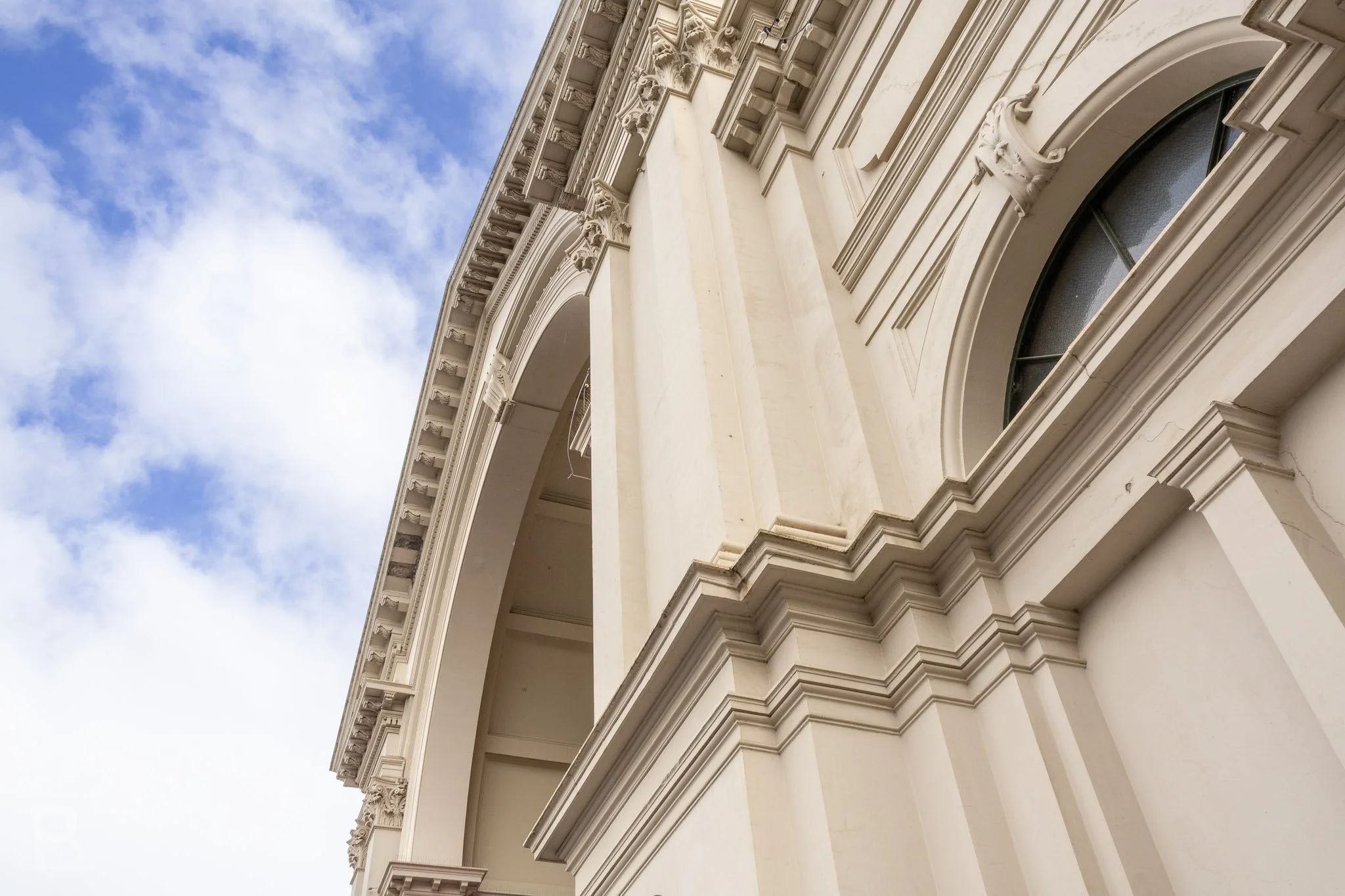 Layered classical detailing follows the curve of a monumental arch,
revealing the precision of the exhibition building's ornament.