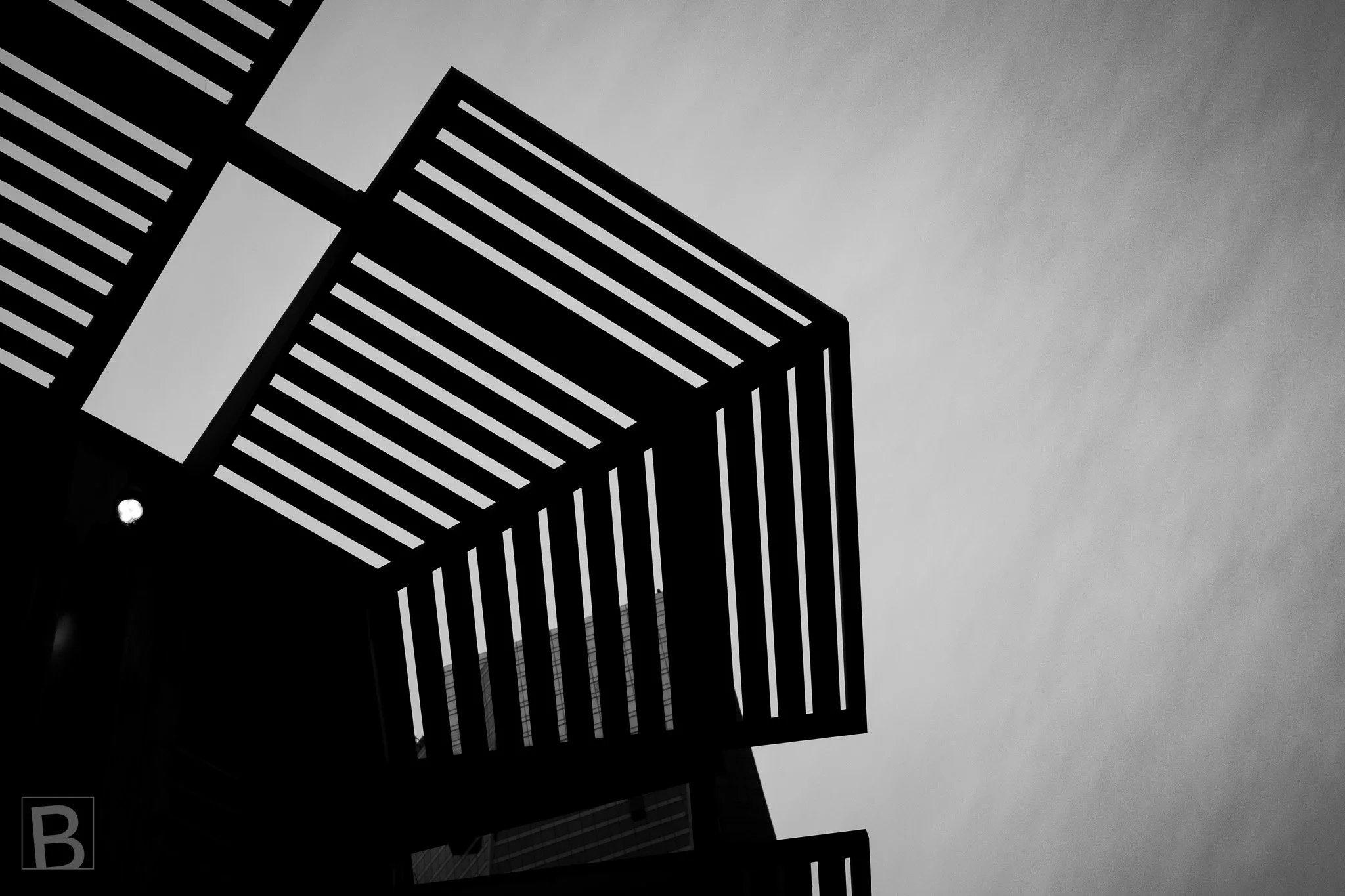Strong parallel slats and a sharply angled frame turn an overhead
shelter into a graphic study of rhythm and space.