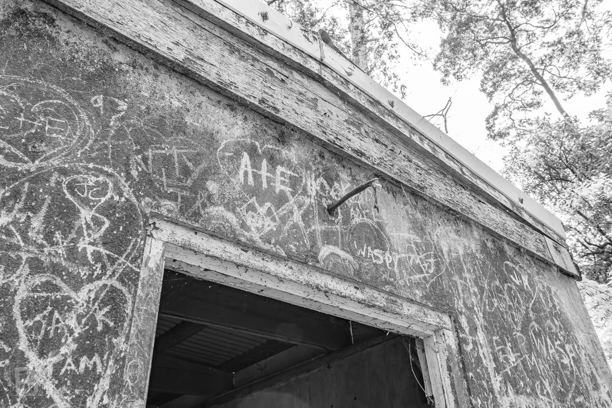 Layers of hand-cut marks record passing visitors across a weathered
building, turning damage into an unintended archive.