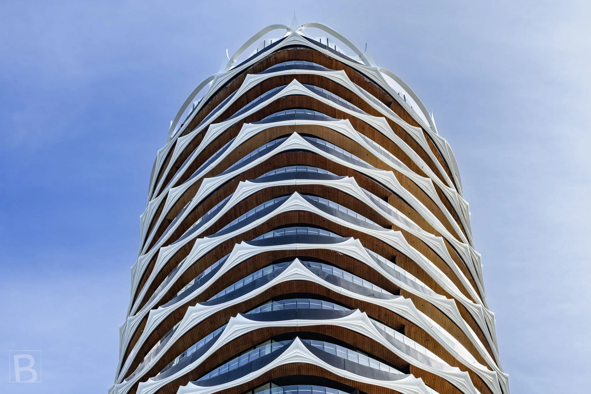 Flowing balcony lines soften the building's height, creating a layered
facade that appears almost woven around the tower.