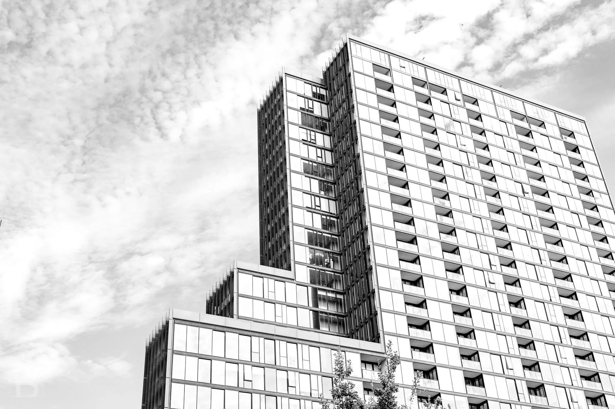 Setbacks divide a tall residential building into shifting blocks, creating
depth and a strong geometric profile.