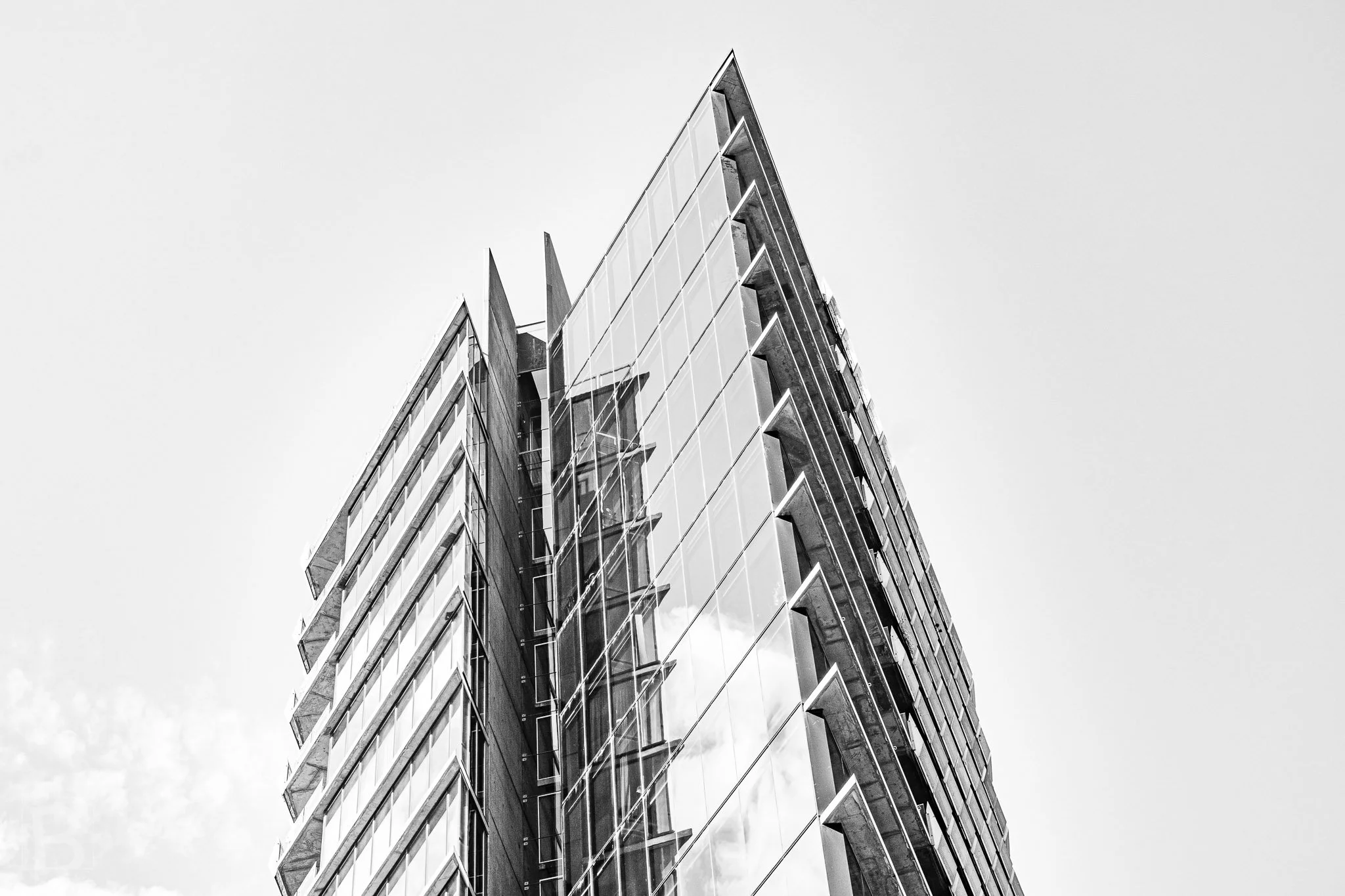 The narrow corner of a modern tower becomes a blade-like form,
defined by fins, balconies and reflected light.