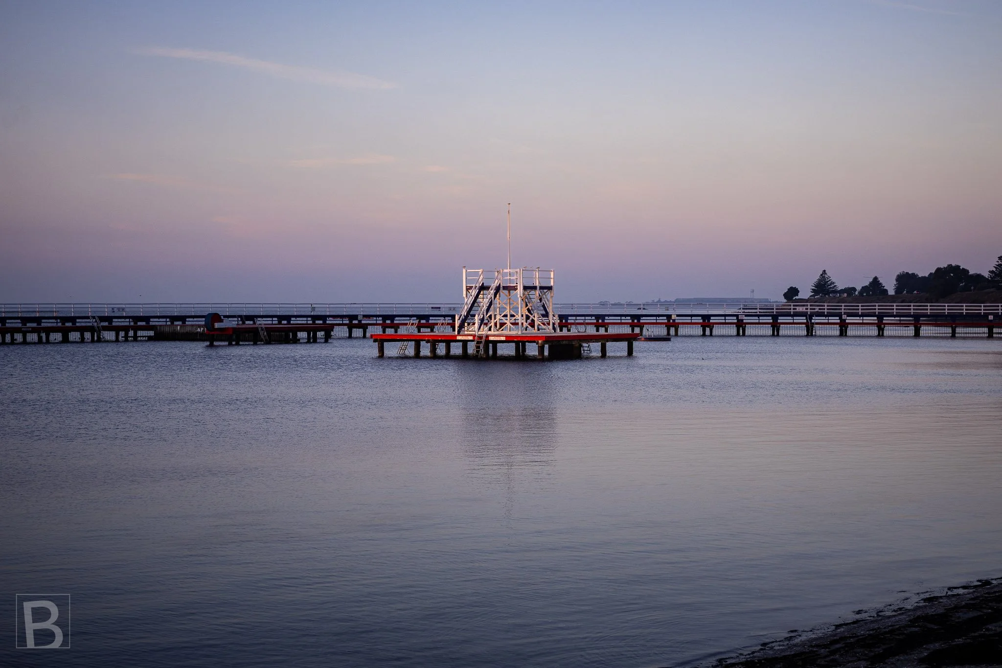 Geelong's historic Eastern Beach diving platform forms a small
geometric landmark within the broad stillness of Corio Bay.
