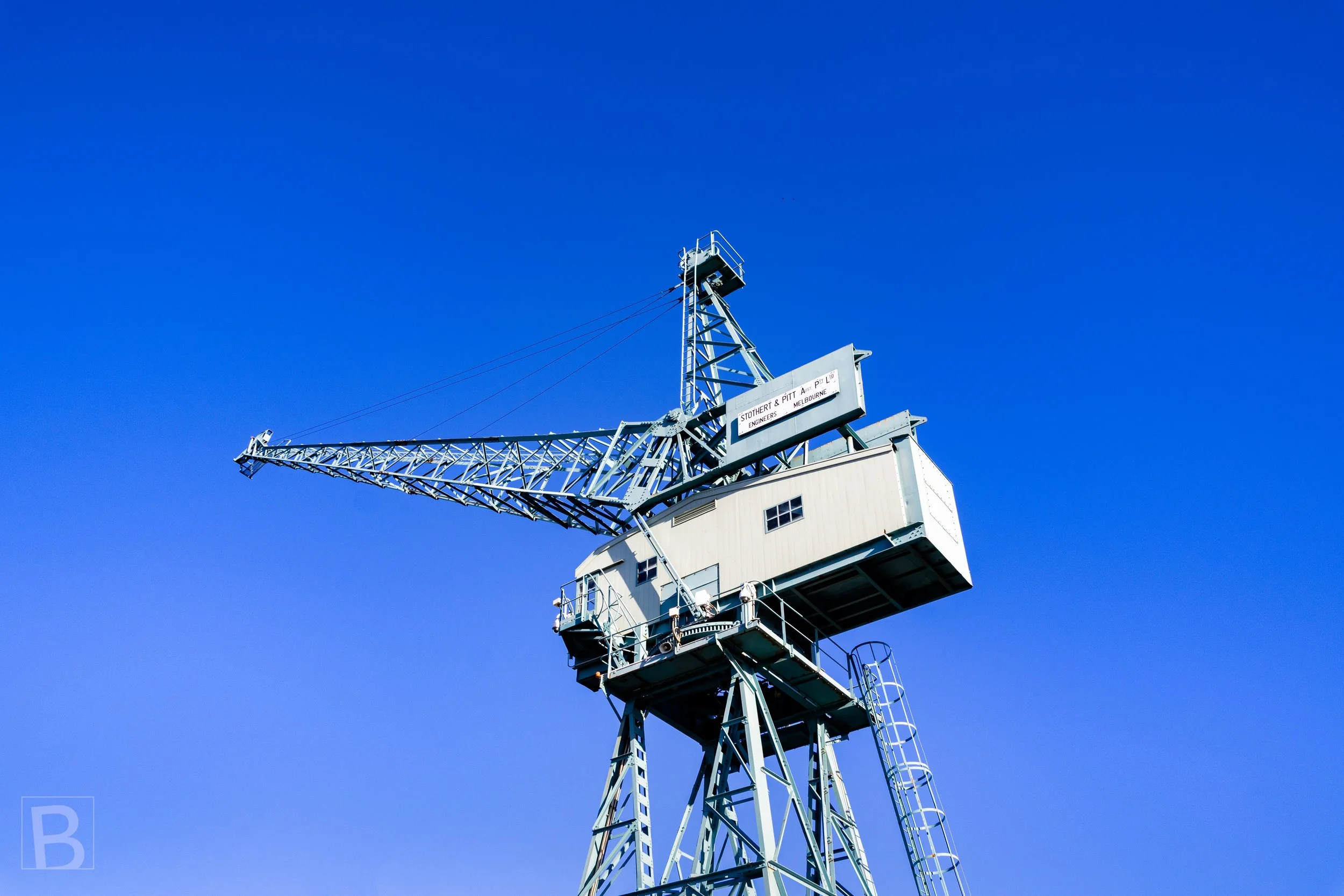 An industrial crane becomes a sculptural landmark when separated
from the busy harbour and framed by uninterrupted blue.