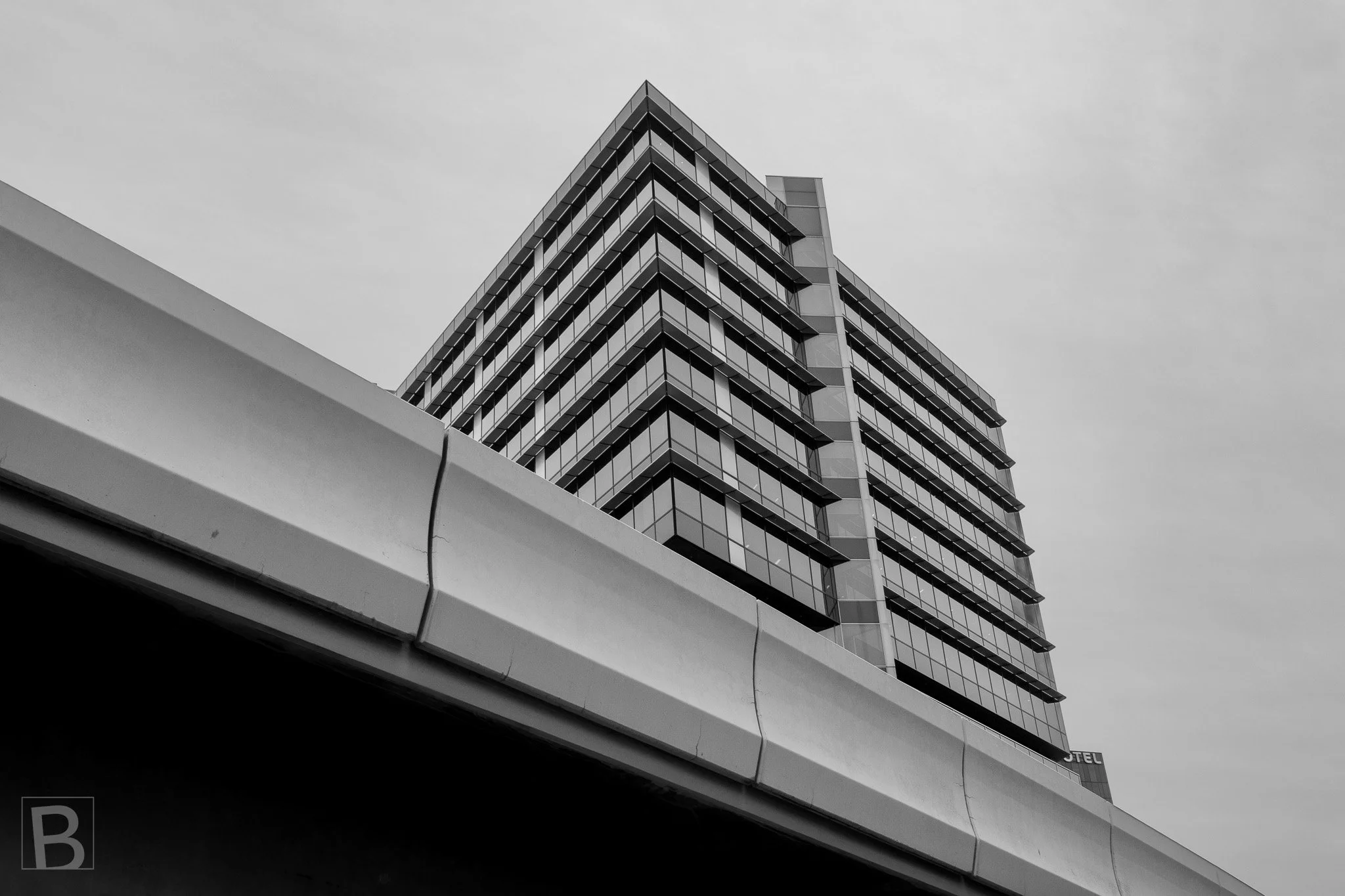 Transport infrastructure cuts across a stacked residential tower,
compressing two scales of urban engineering into one view.