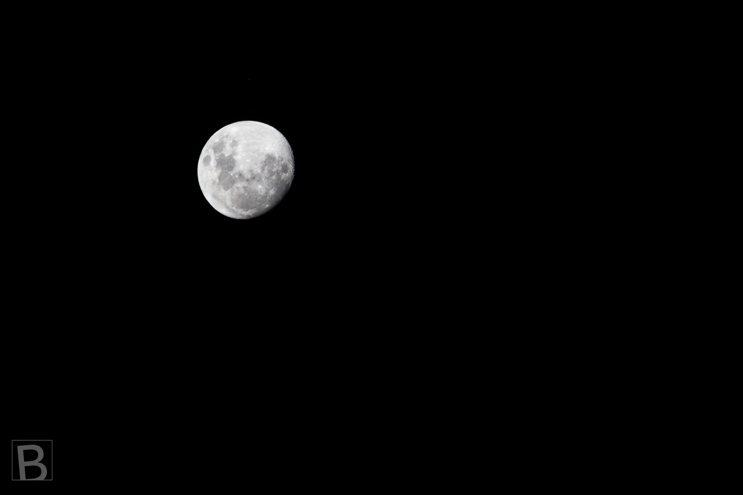 The illuminated surface of the moon is isolated against darkness in a
minimal study of texture, distance and stillness.