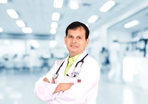 A male doctor wearing a white coat and a stethoscope in a medical facility.
