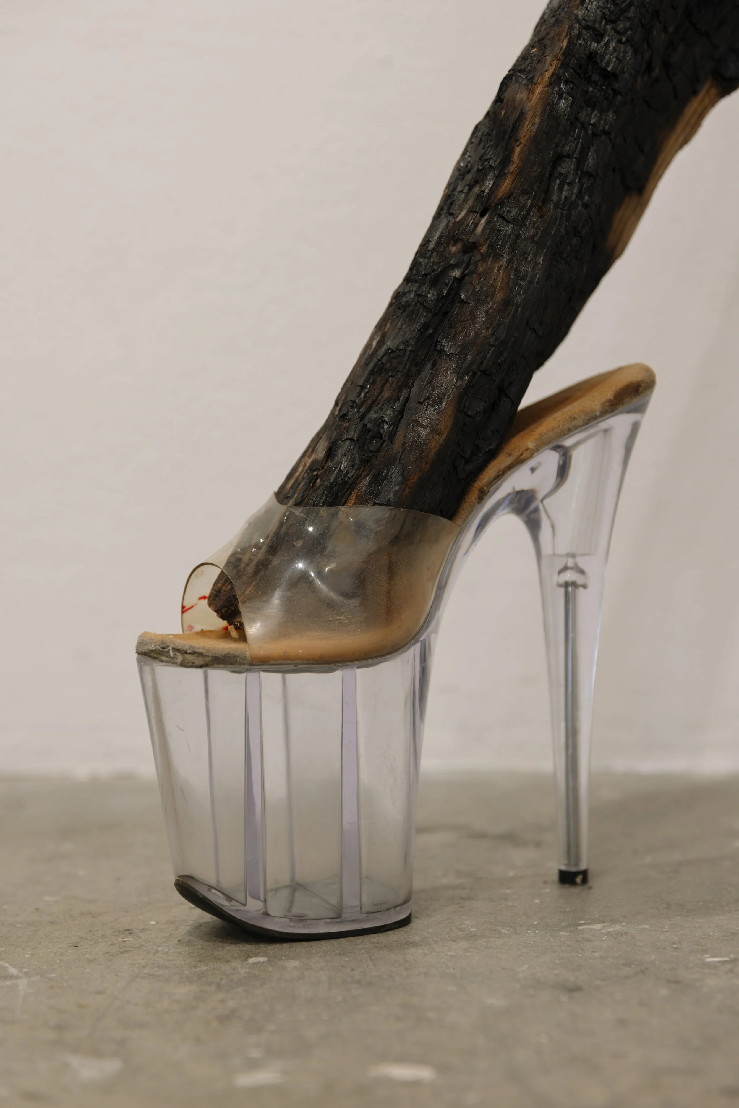 SEXYlegs (detail shot), 2022
materials: 2 burnt logs, pleasers, soy wax, salvaged burnt brick, silicone caulk and piercing jewelry 
23" x 7” x 52"