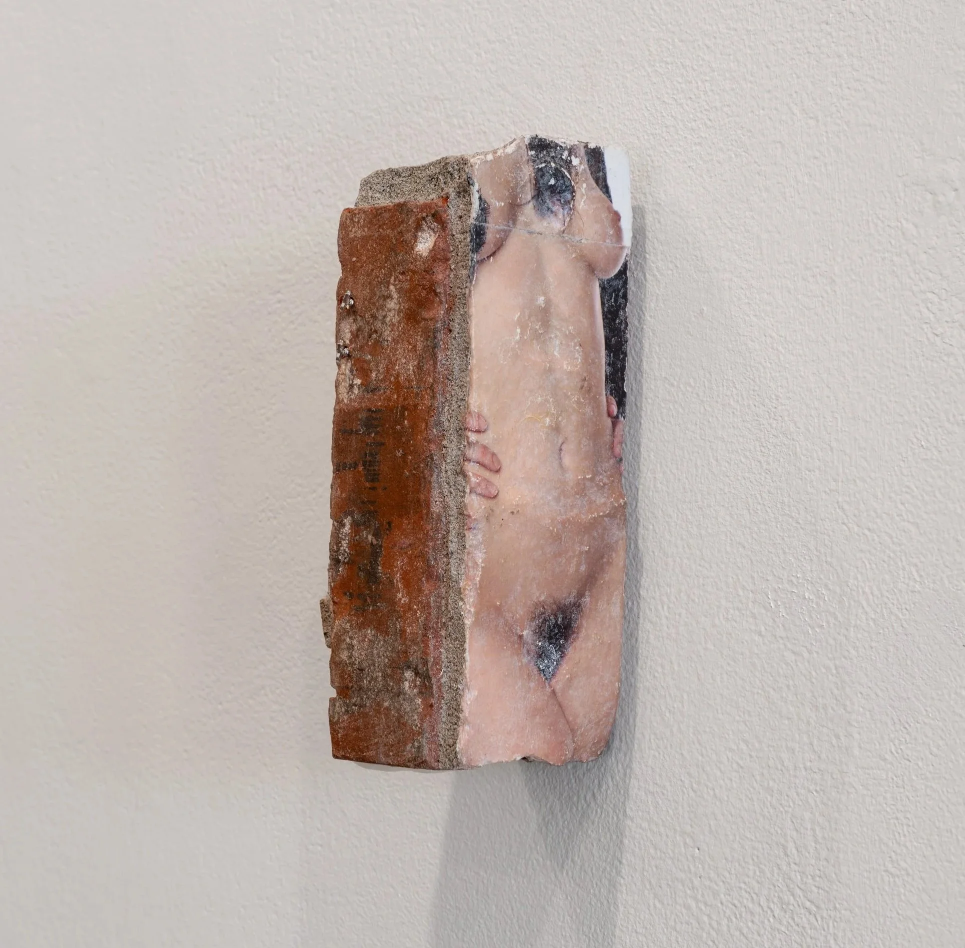 succubus, 2026
materials: salvaged brick, exotic magazine image transfer, silicone caulk, soy wax and piercing jewelry 
3.5" x 3" x 9"