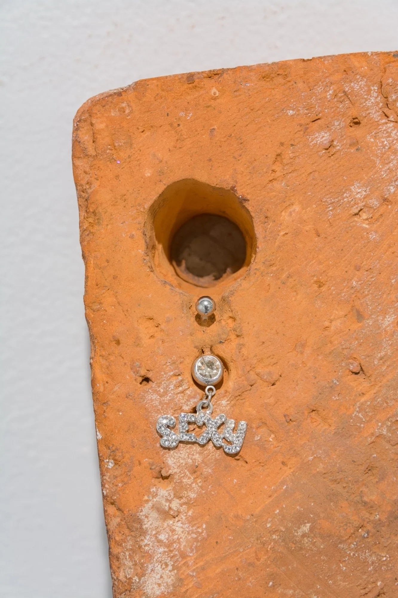 Untitled4 (close up image), 2021-2022
Materials: Two burnt logs, clear 8-inch Pleaser heels, soy wax, partially burnt brick, silicone caulk, ‘SEXY’ belly button piercing jewelry, monotype prints, Exotic magazine images, brick dust