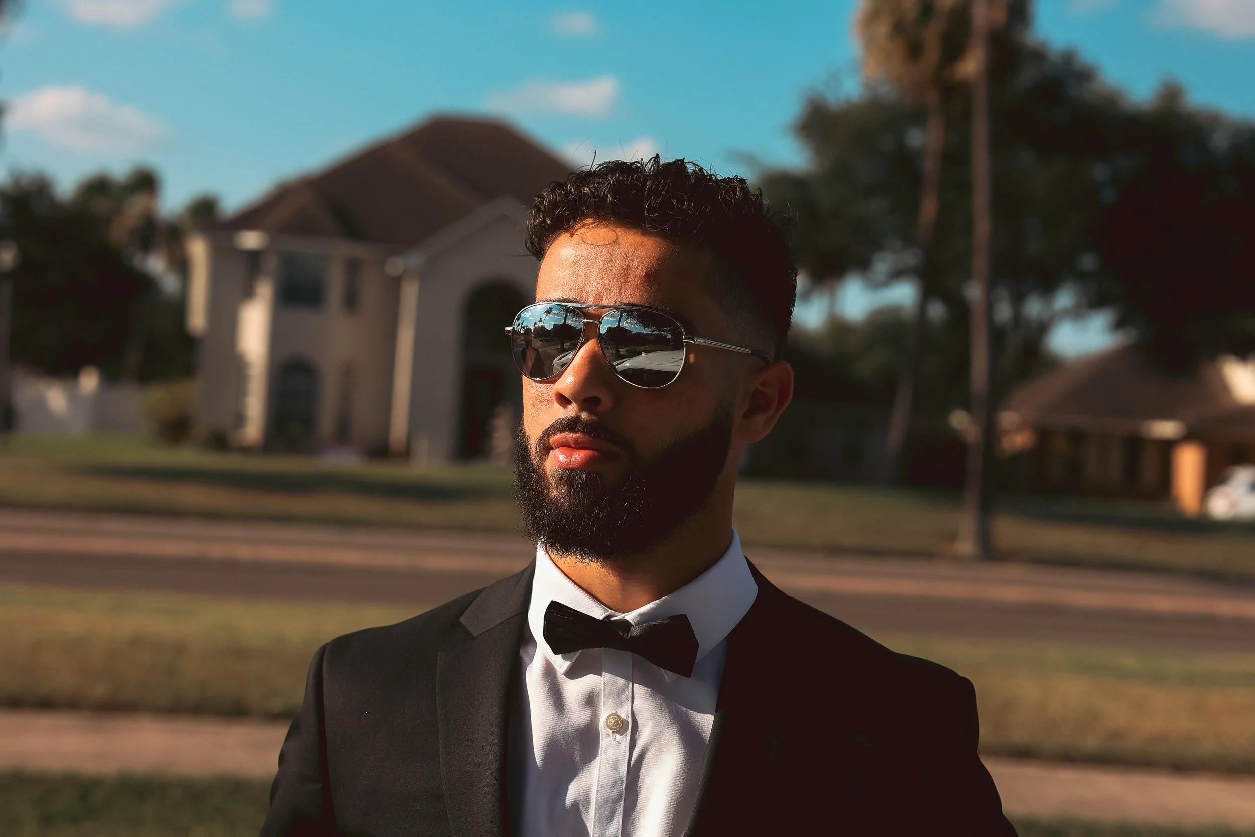 Sunglasses, tuxedo, and a blue sunny Texas sky.