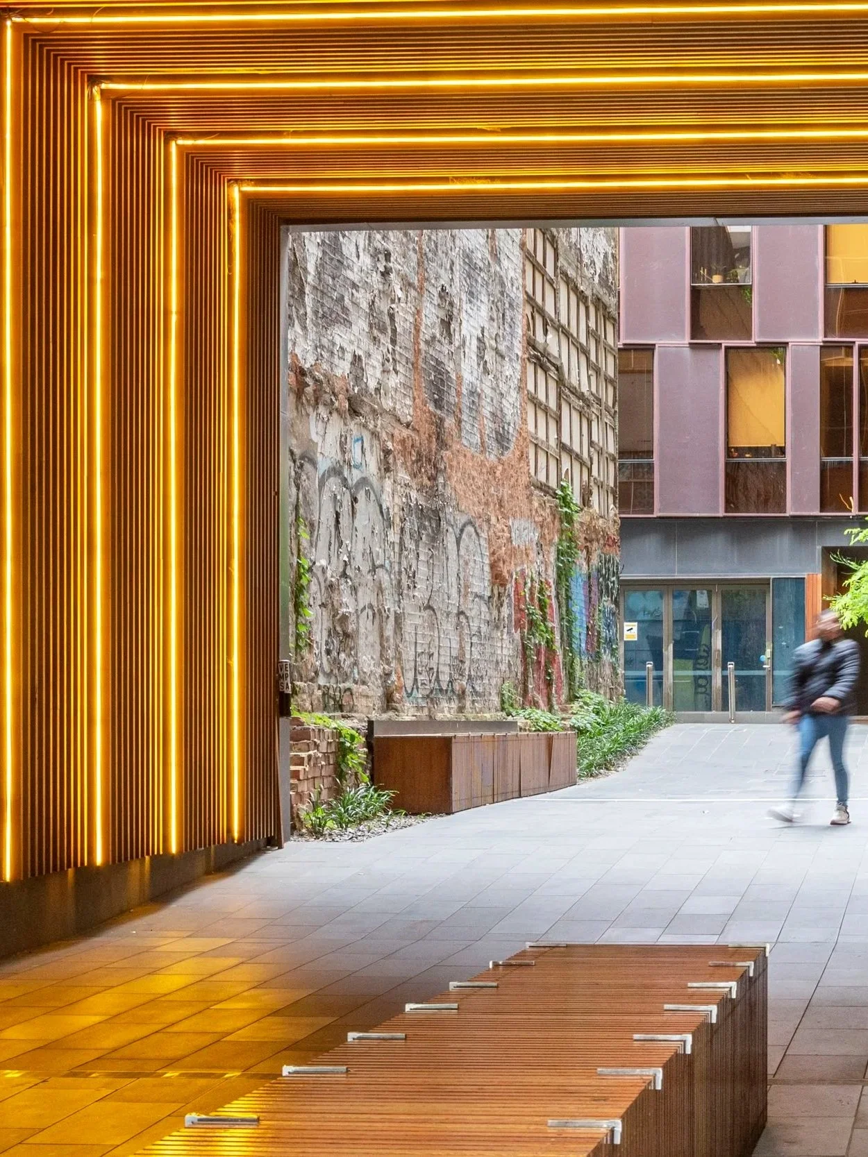 Strips of yellow led lights are installed on the roof and wall of the transitional tunnel, together with the texture cladding on the roof and wall creating a sophiticated texture.