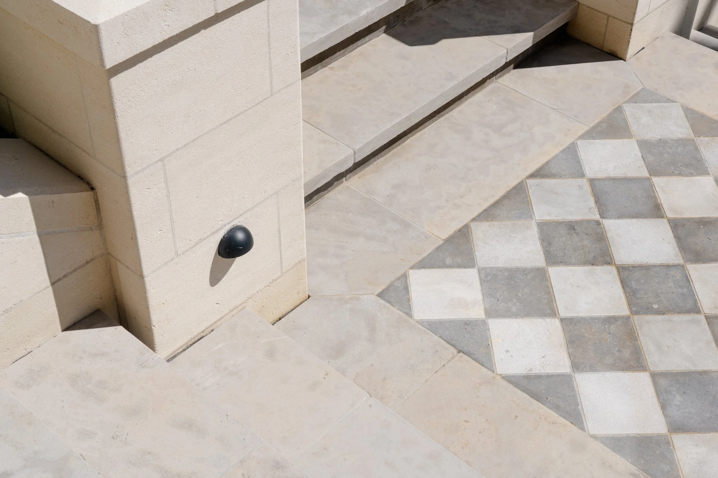 The black and white stone pavers infill create an eye-catching pattern the very first step people enter the garden.
