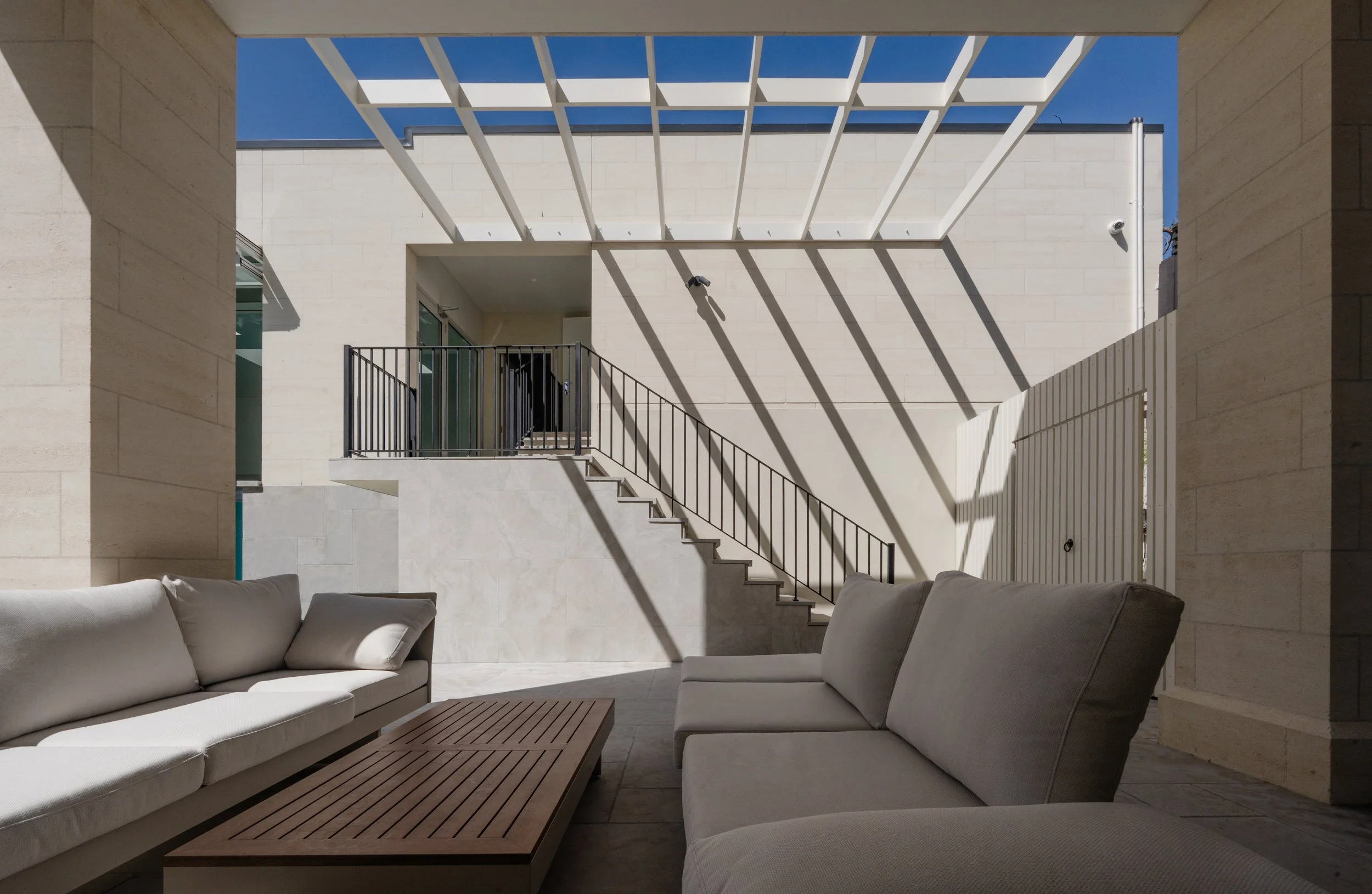 The timber beams casting shades on the wall of the garage, creating a beautiful scenery from the outdoor roof area.