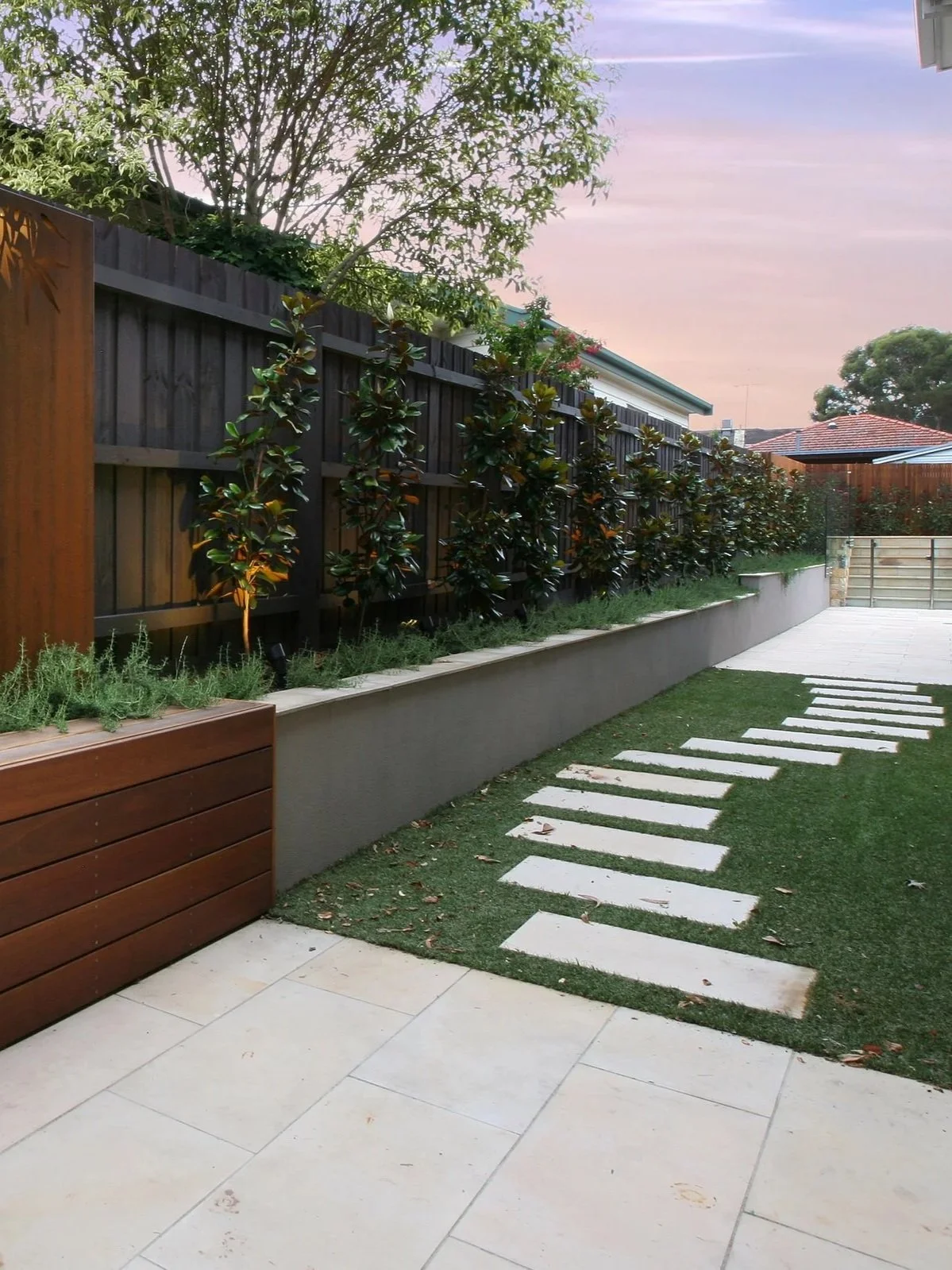 The white sandstone pavings and stepping stone gives great contrast with the lawn and vegetation.