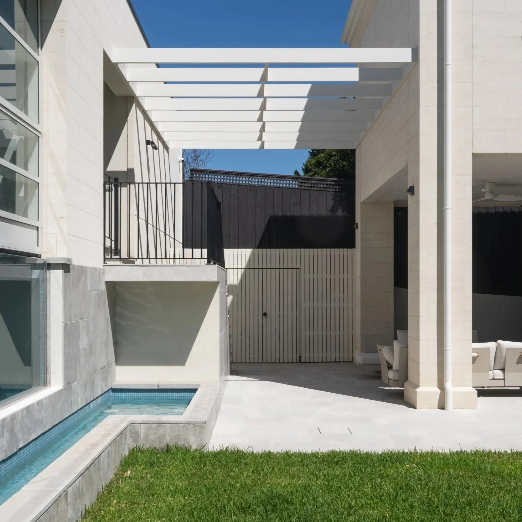 A luxury garden with limestone pavings matching with the architecture facade, and an indoor pool house.