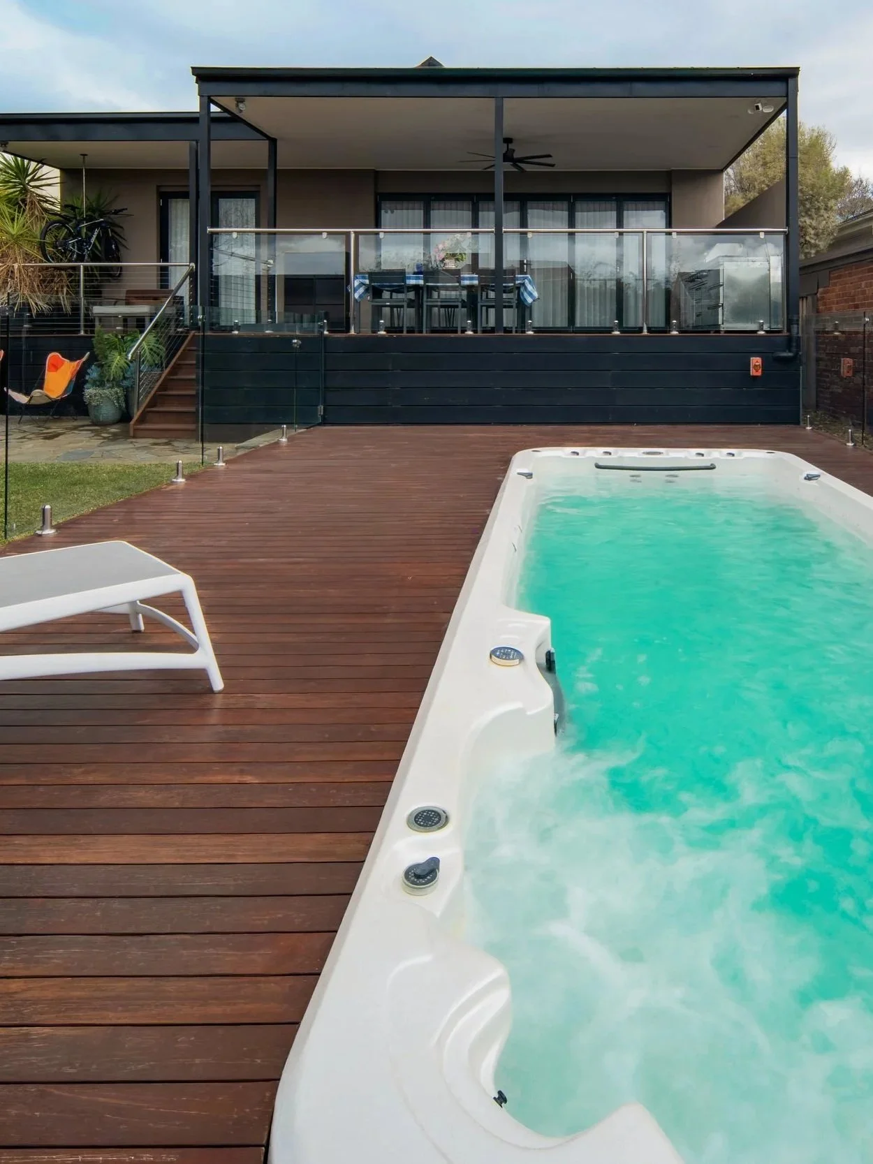 A swim spa at the backyard garden on timber decking. Timber works are chosen to match with the architecture yellow brownish tone.