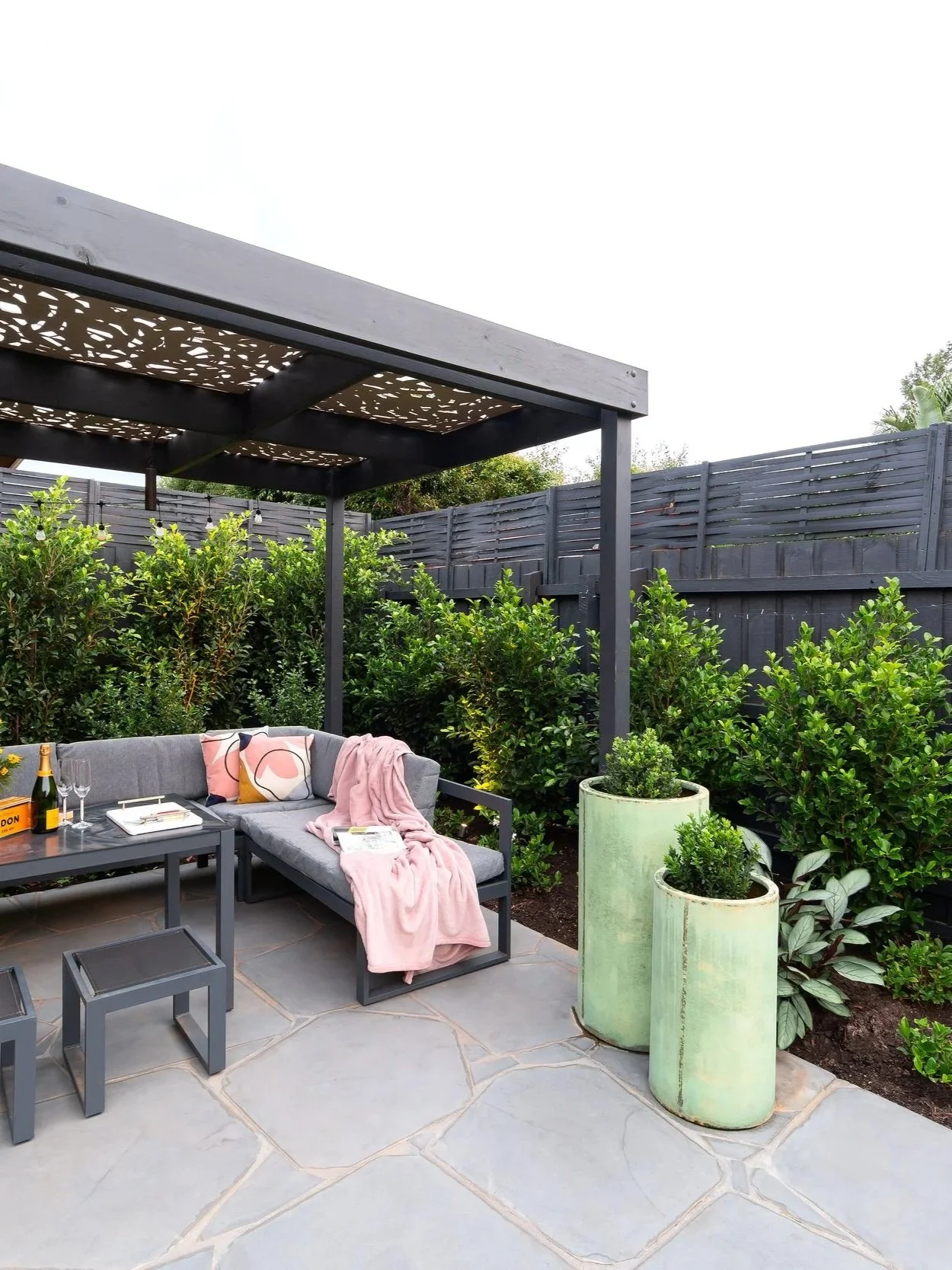 The pergola with stone paving and urns gives off a high-class feeling.