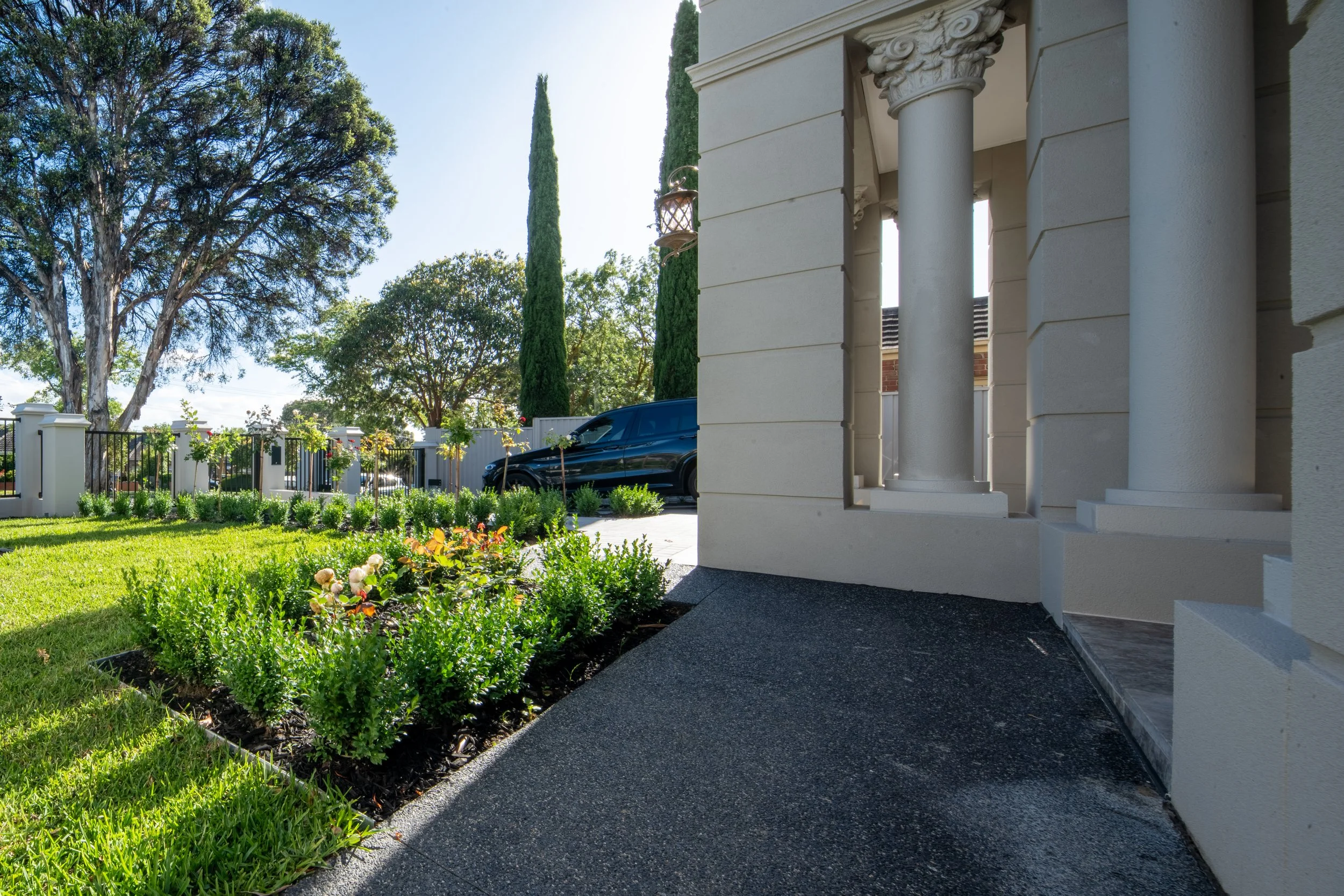 The front garden, with two strips of plantations along entrance walkway and a lawn. Front fence is to match with the architecture.