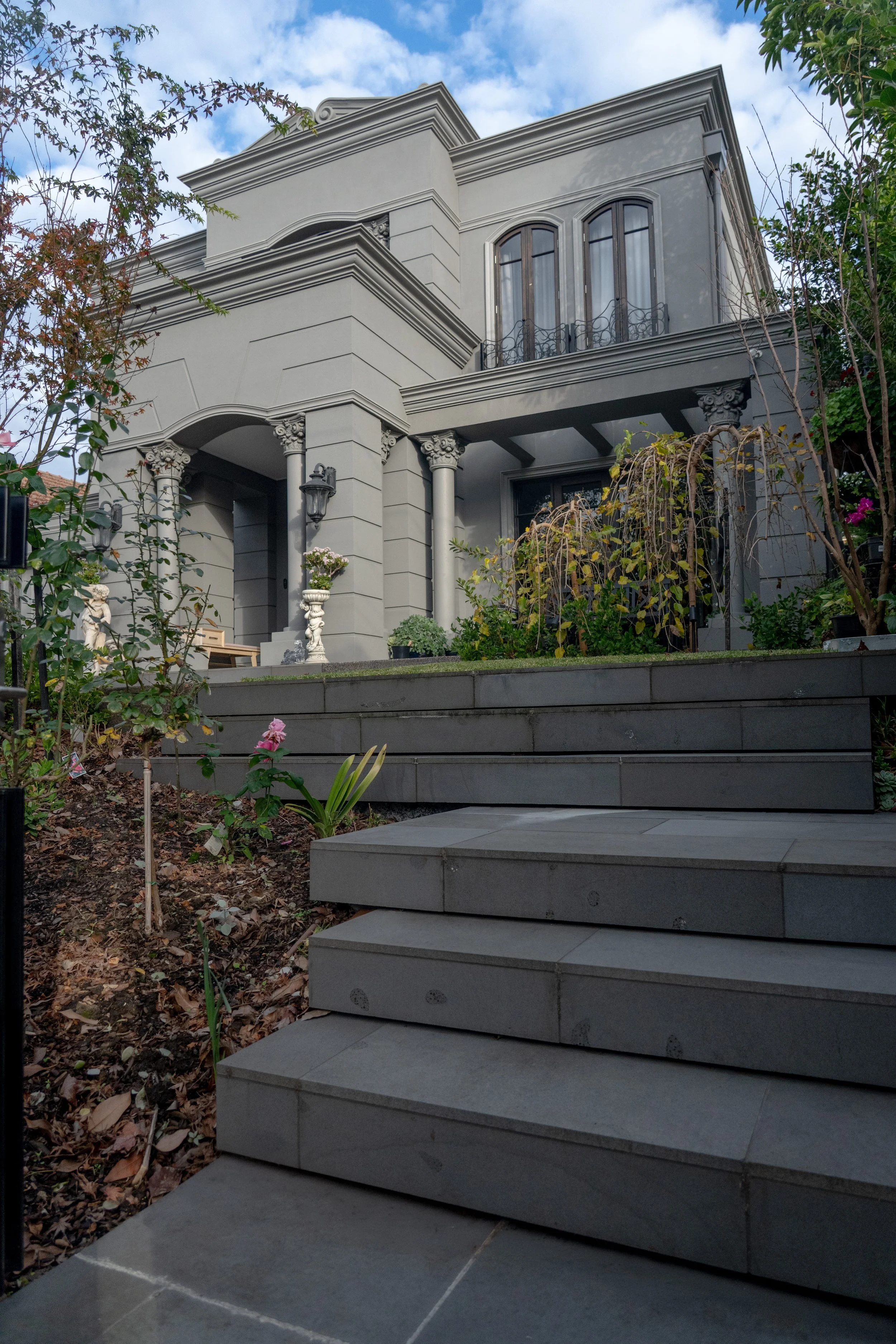 The blustone paved steps going up to the front yard of the mansion, with diversified selection of plantations around.