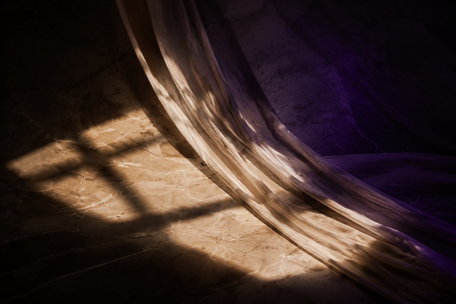 Close-up view of a marble or stone surface with a curved, translucent purple and beige fabric or material draped over it, with shadows cast across the surface.