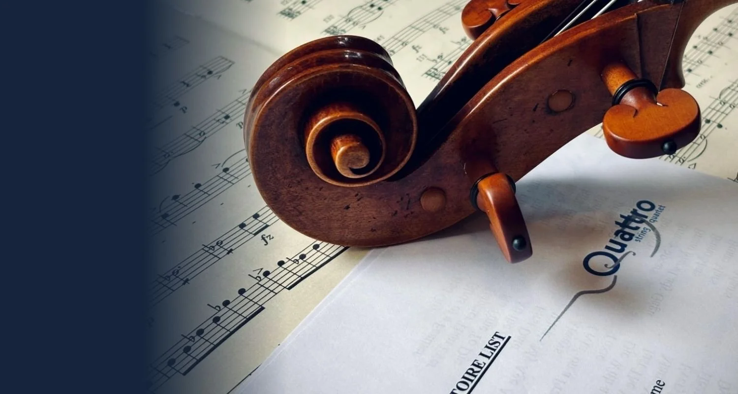 Close-up of a wooden violin scroll resting on sheet music and a notepad with 'QUOTE' and 'STORE LIST' written on it.