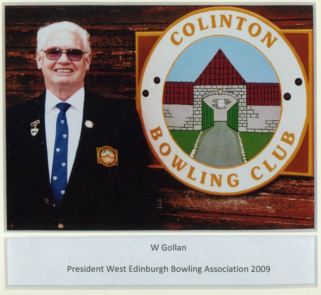 A man wearing sunglasses, a suit, and a tie, standing next to a sign for the Columbia Bowling Club. The sign features a drawing of a barn with a pathway leading to an open gate. A plaque in front of the display identifies him as W Gollan, President o