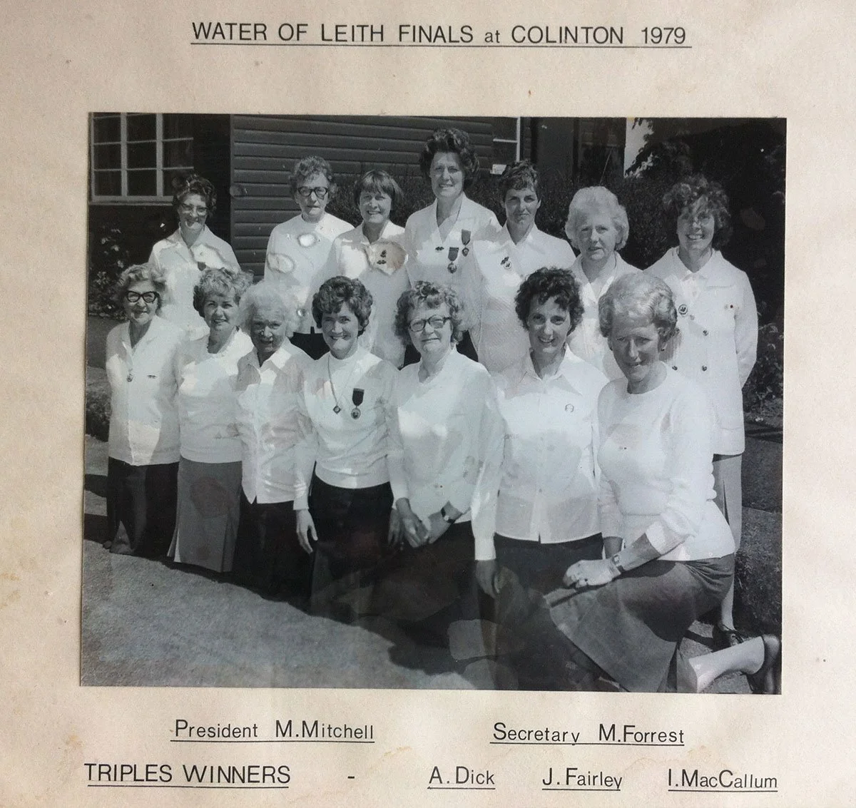 Black and white photograph of a group of women, possibly members of a club or team, standing outdoors in front of a building. Some women are wearing medals. The caption indicates they are participants in the Water of Leith Finals at Colinton in 1979,