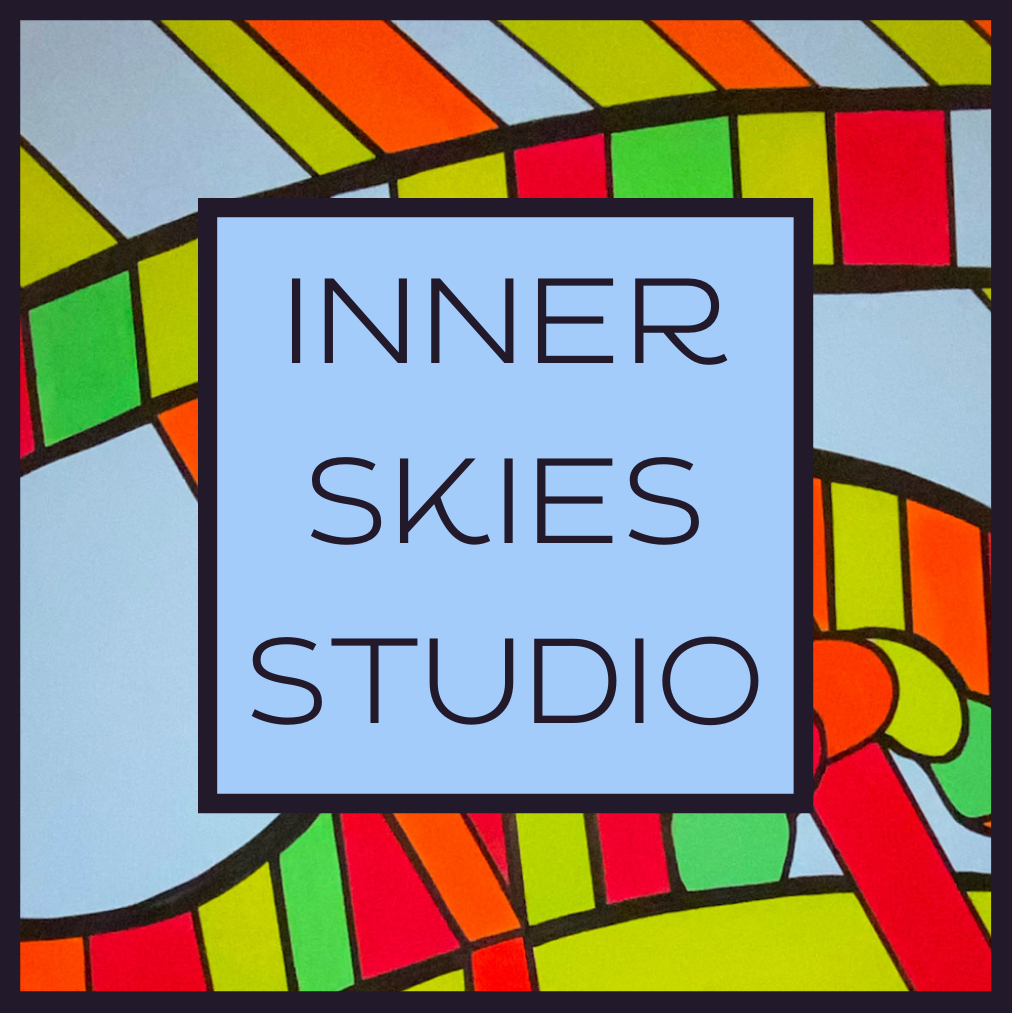 Colorful stained glass window with a blue square in the center containing the text "Inner Skies Studio" in black letters.