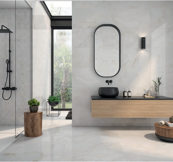 Modern bathroom with a walk-in shower on the left, a large window, and a minimalist vanity with a black sink and mirror on the right.