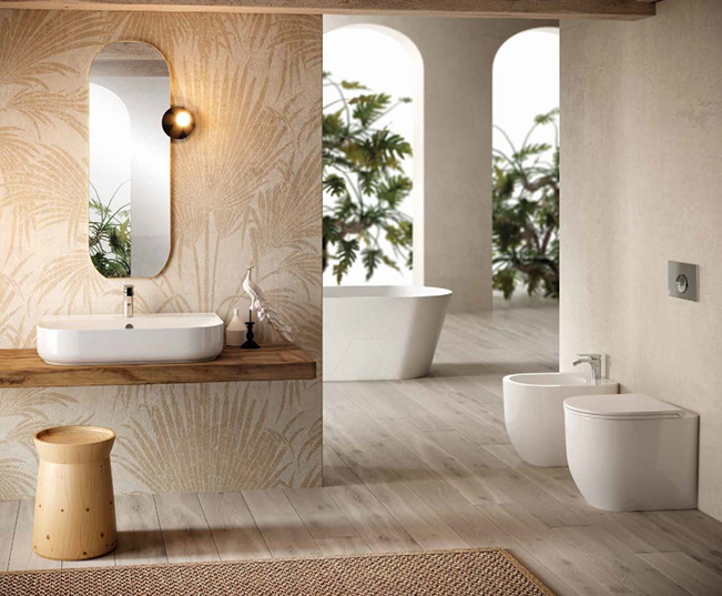 Modern bathroom with a floating sink, oval mirror, wall sconce, wooden stool, free-standing bathtub, and wall-mounted toilet and bidet, with large windows and greenery outside.