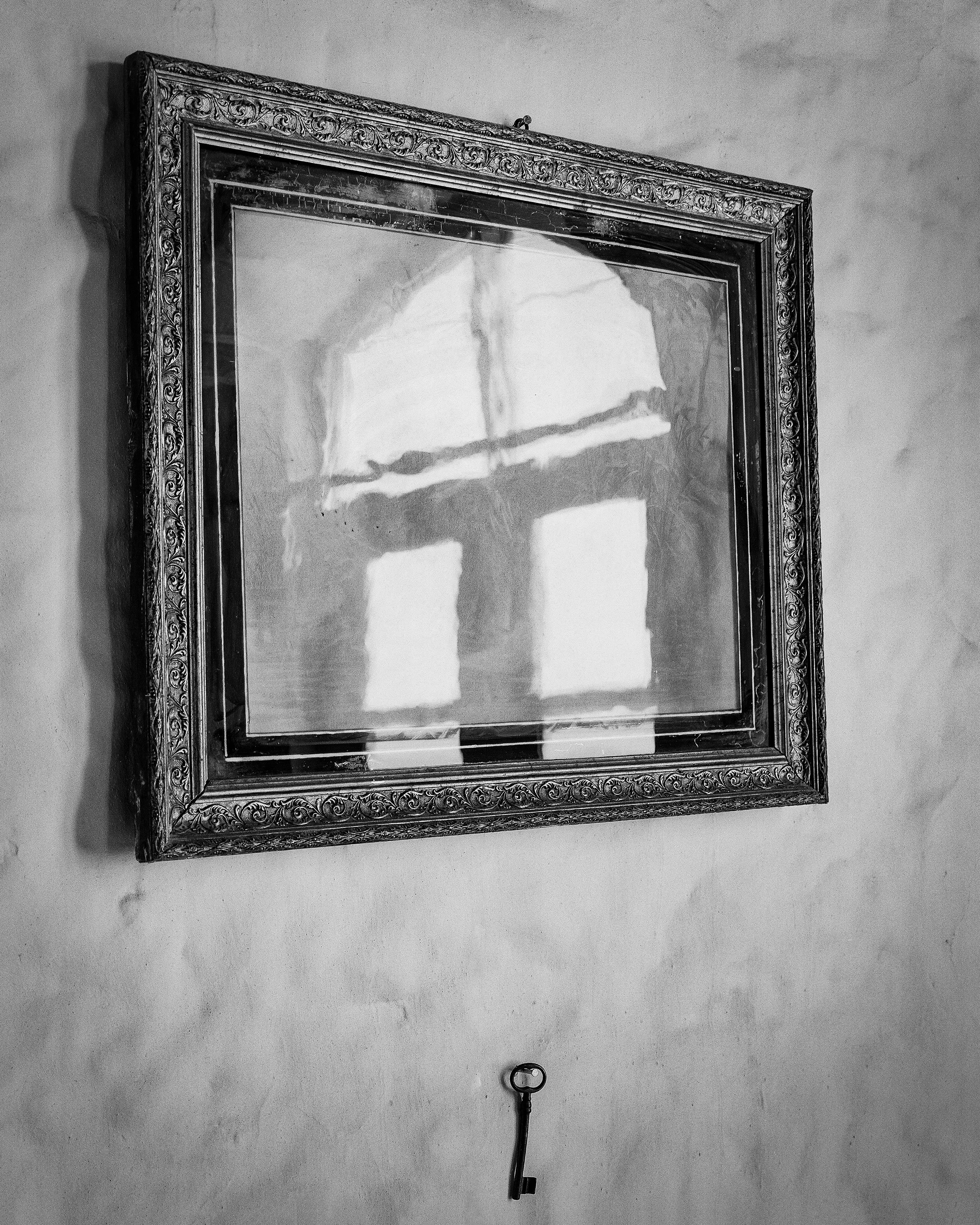 Harbour of the Soul. The Key. An iron key hanging on a wall below a framed picture.